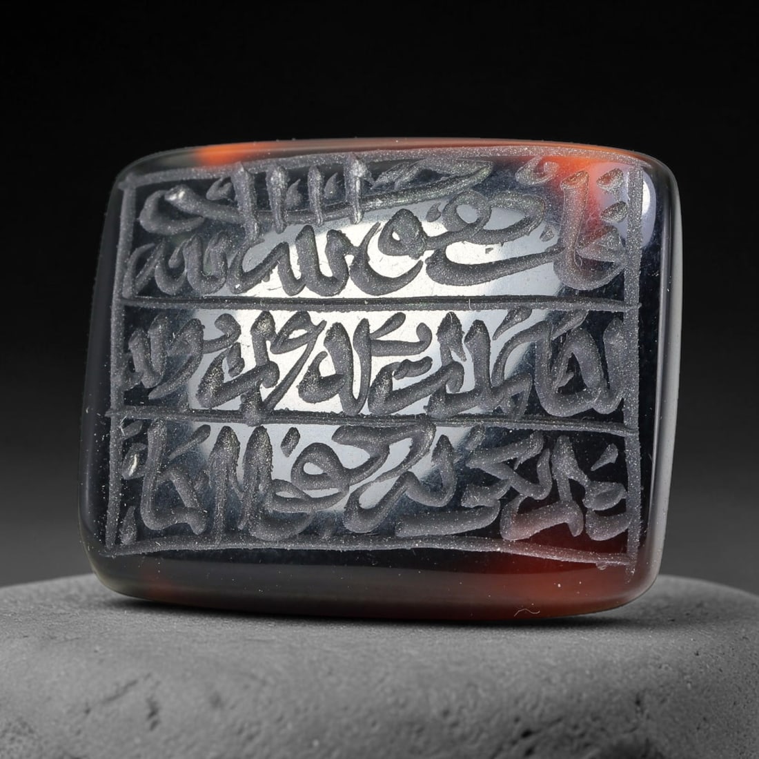 Ancient Medieval Mughal Islamic Carnelian Agate Calligraphic Script Talisman 1526-1857 CE, 27ET: Polished rich-toned carnelian agate cabochon, finely engraved with divided panels of Islamic calligraphic intaglio inscriptions. Deep crisp engraving features segmenting incised lines organizing the s