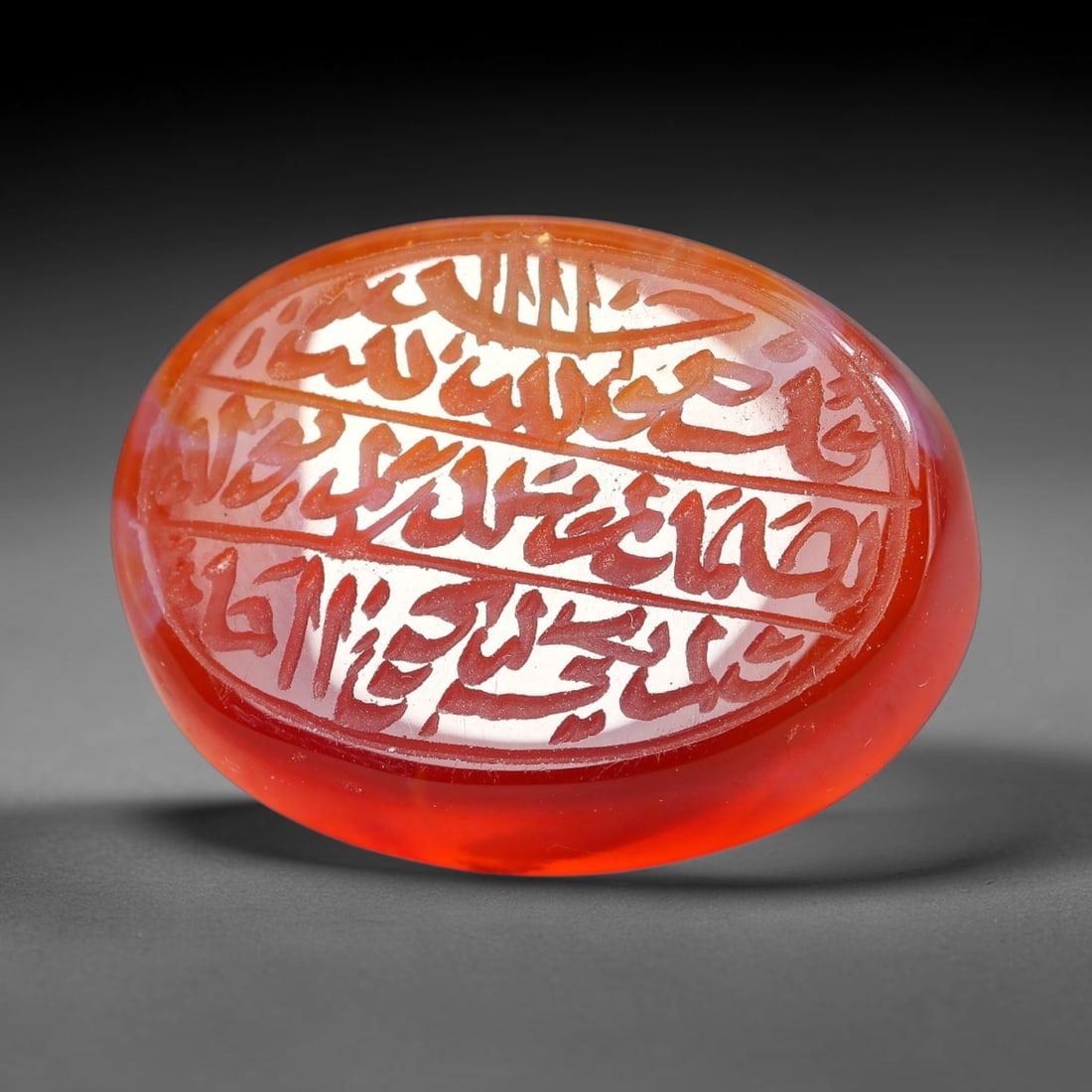 Ancient Medieval Mughal Islamic Carnelian Agate Calligraphic Script Talisman 1526-1857 CE, 29ET: Polished rich-toned carnelian agate cabochon, finely engraved with divided panels of Islamic calligraphic intaglio inscriptions. Deep crisp engraving features segmenting incised lines organizing the s