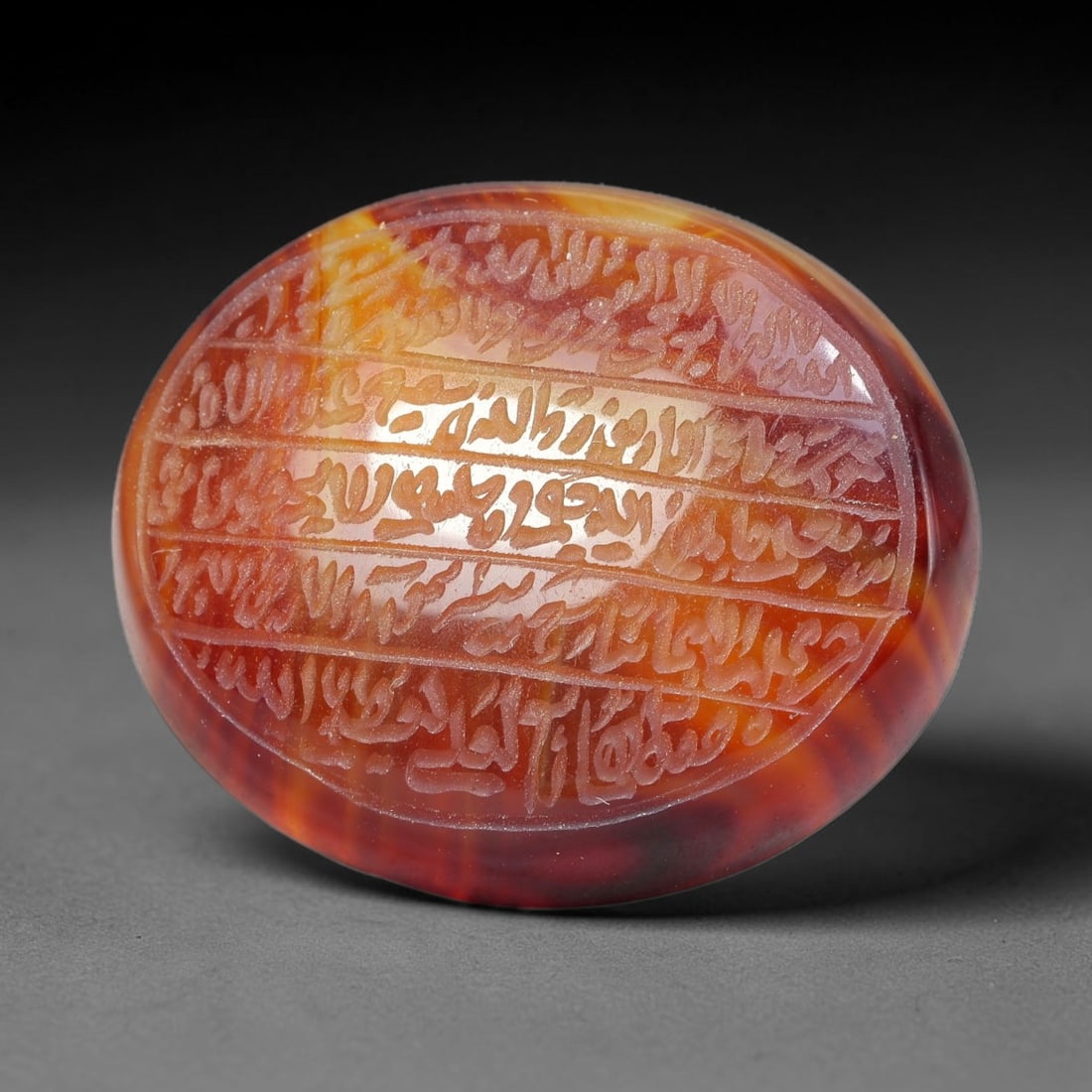 Ancient Medieval Mughal Islamic Carnelian Agate Calligraphic Script Talisman 1526-1857 CE, 88ES: Polished rich-toned carnelian agate cabochon, finely engraved with divided panels of Islamic calligraphic intaglio inscriptions. Deep crisp engraving features segmenting incised lines organizing the s