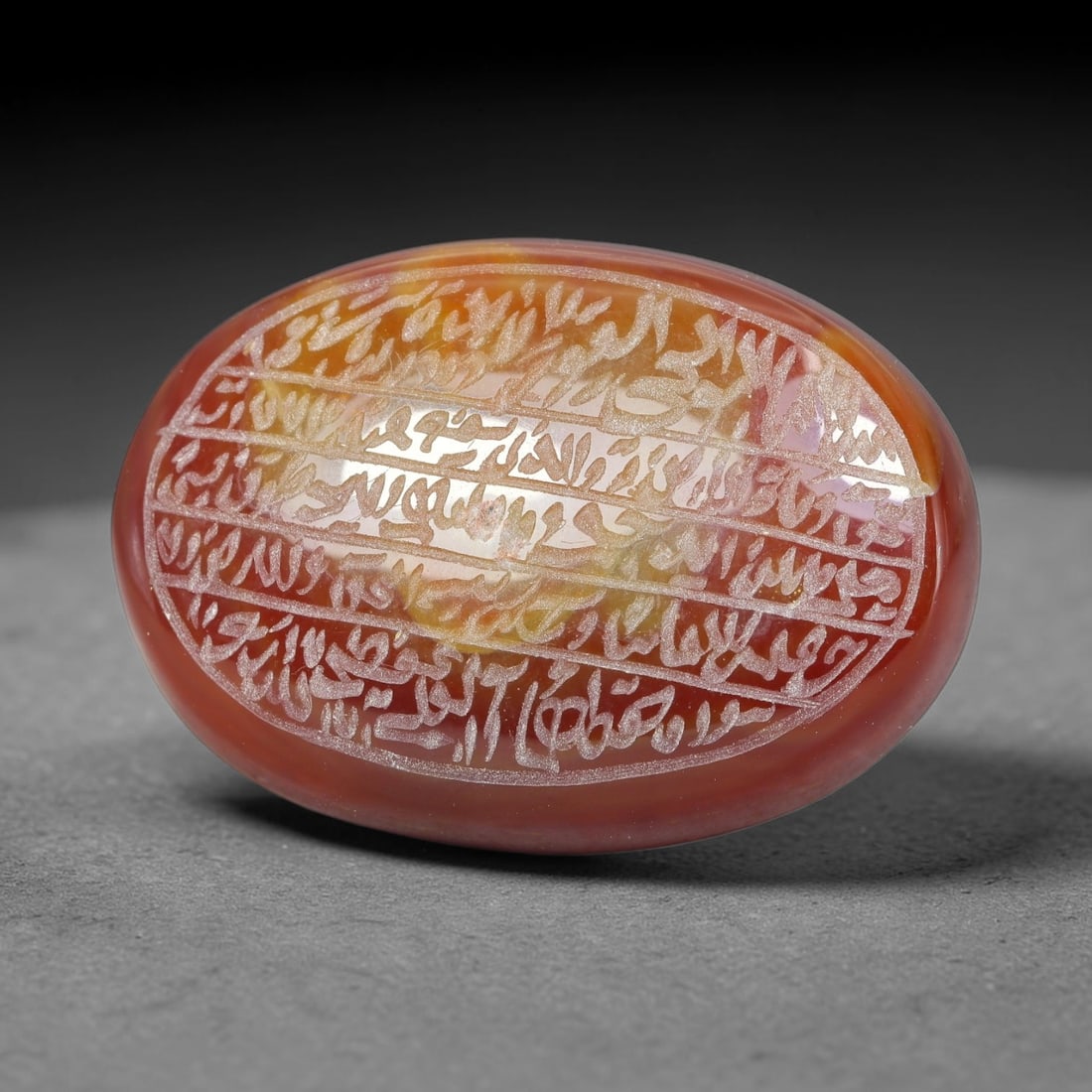 Ancient Medieval Mughal Islamic Carnelian Agate Calligraphic Script Talisman 1526-1857 CE, 76ES: Polished rich-toned carnelian agate cabochon, finely engraved with divided panels of Islamic calligraphic intaglio inscriptions. Deep crisp engraving features segmenting incised lines organizing the s