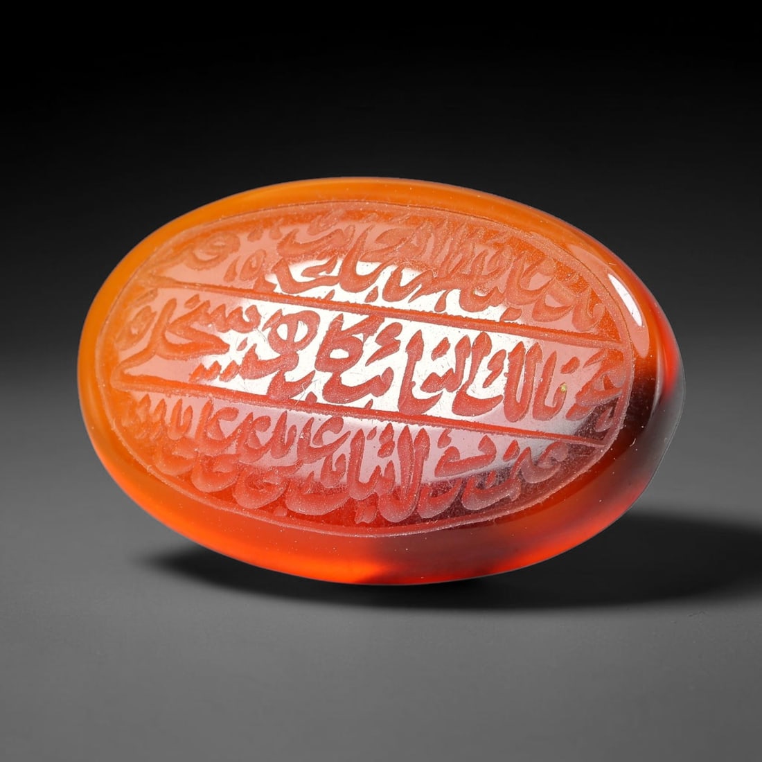 Ancient Medieval Mughal Islamic Carnelian Agate Calligraphic Script Talisman 1526-1857 CE, 36ET: Polished rich-toned carnelian agate cabochon, finely engraved with divided panels of Islamic calligraphic intaglio inscriptions. Deep crisp engraving features segmenting incised lines organizing the s