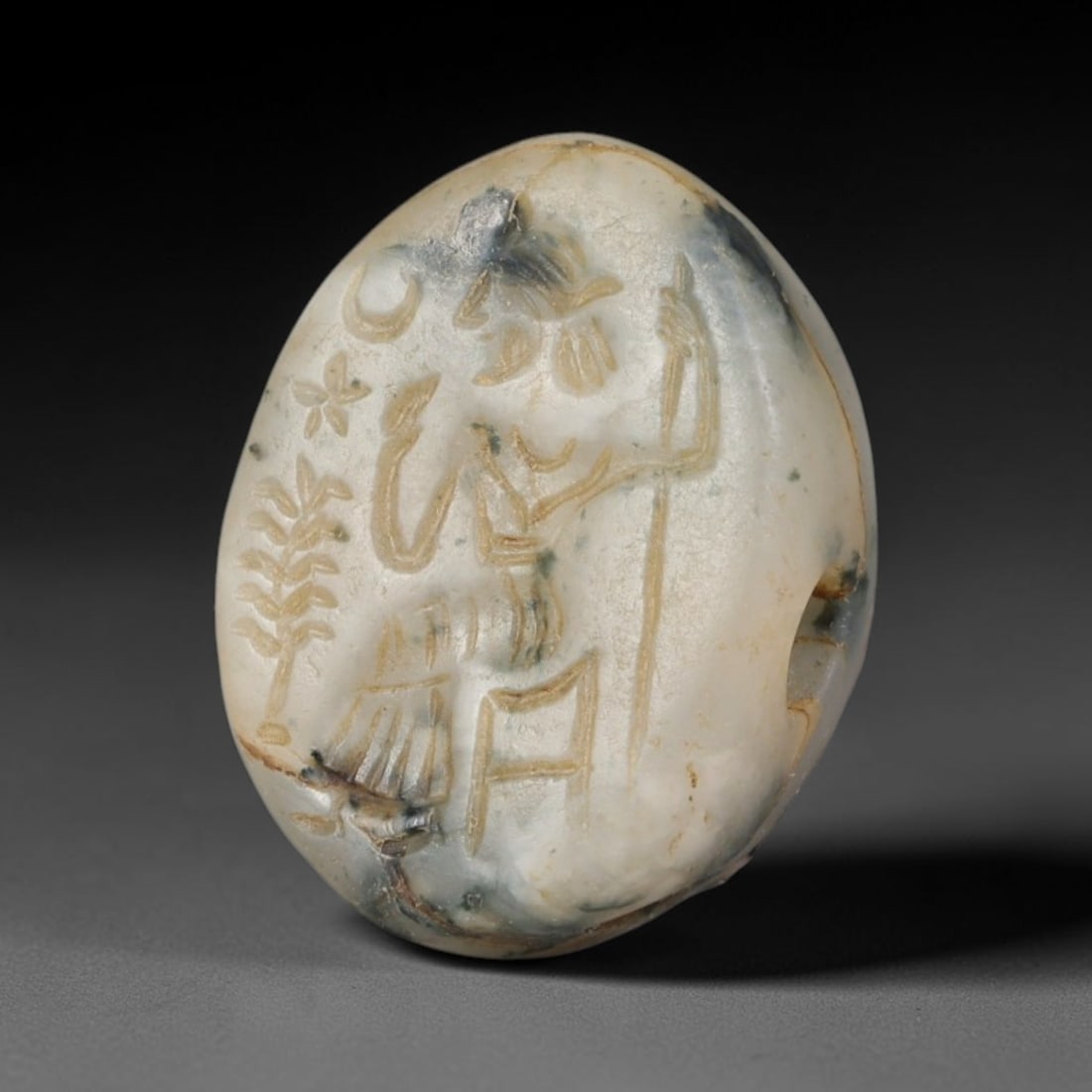 Ancient Sasanian Persian Stamp Seal (c.224-651 CE), 59EF: This mottled pale stone oval stamp seal originates from Ancient Sasanian Persian culture. The sealing face features finely incised figural iconography alongside symbolic motifs, executed in characteri