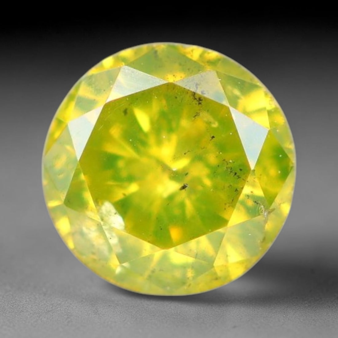 0.19ct Round Natural Fancy Vivid Yellow Diamond Loose Gemstone, 100BE: This polished natural round fancy diamond exhibits vibrant saturated yellow colour, with fine microscopic native mineral specks visible inside the crystal, measured at calibrated dimensions of 3.8x2.1