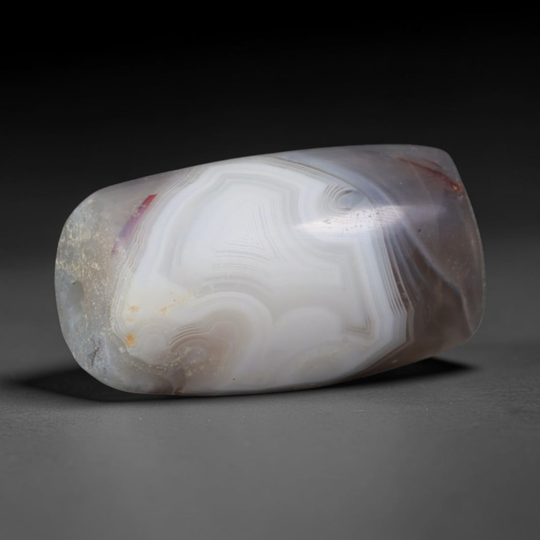 Ancient Mitannian Bronze Age Swirl Eye Banded Agate Barrel Bead (1600-1260 BCE), 69AD: This antique banded agate barrel bead originates from the Mitannian Bronze Age Civilization of Northern Mesopotamia, a culture celebrated for elite agate lapidary production supplying ritual talismans
