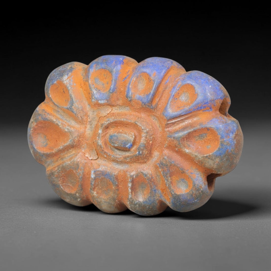 Ancient Achaemenid Persian Lapis Lazuli Rosette Bead (550-330 BCE), 2ER: This finely carved pendant bead is fashioned from rich lapis lazuli originating from the Achaemenid Persian Empire, decorated with a symmetrical rosette floral motif featuring incised leaf and lattice