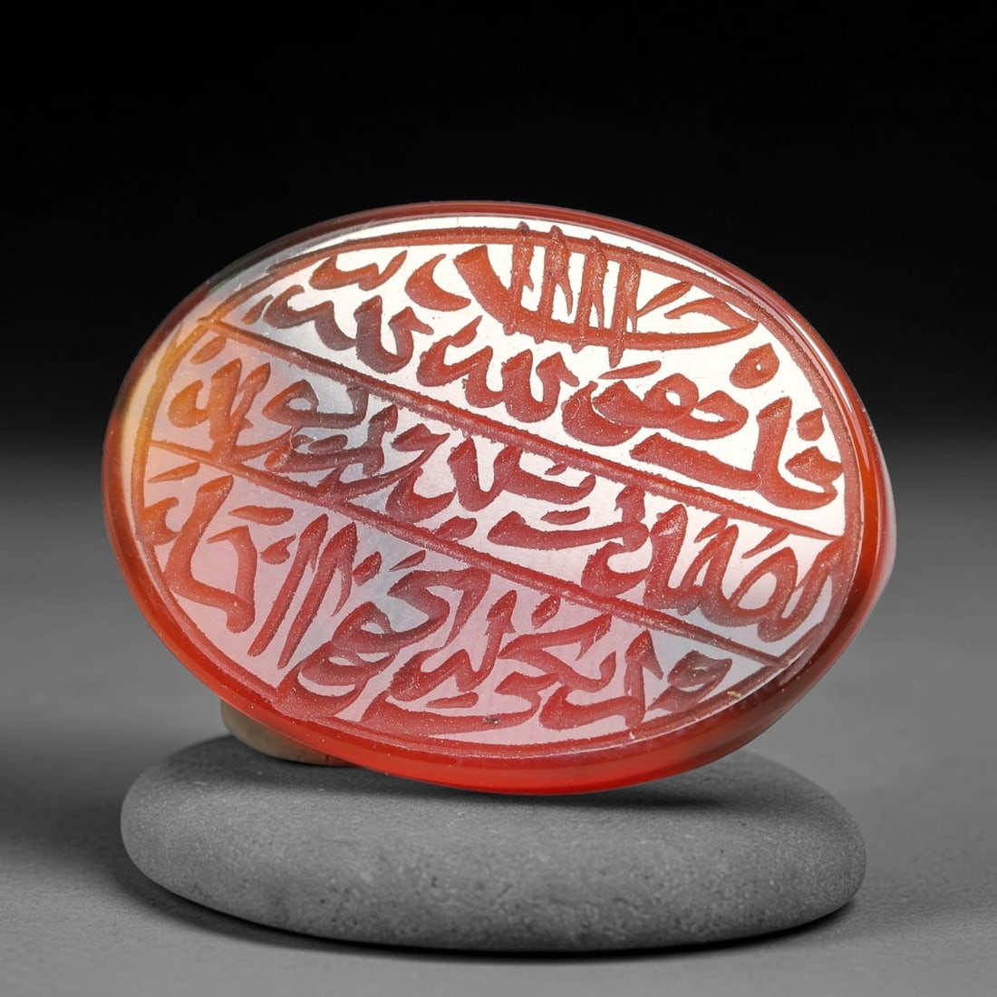 Ancient Medieval Mughal Islamic Carnelian Agate Calligraphic Script Talisman 1526-1857 CE, 26ET: Polished rich-toned carnelian agate cabochon, finely engraved with divided panels of Islamic calligraphic intaglio inscriptions. Deep crisp engraving features segmenting incised lines organizing the s