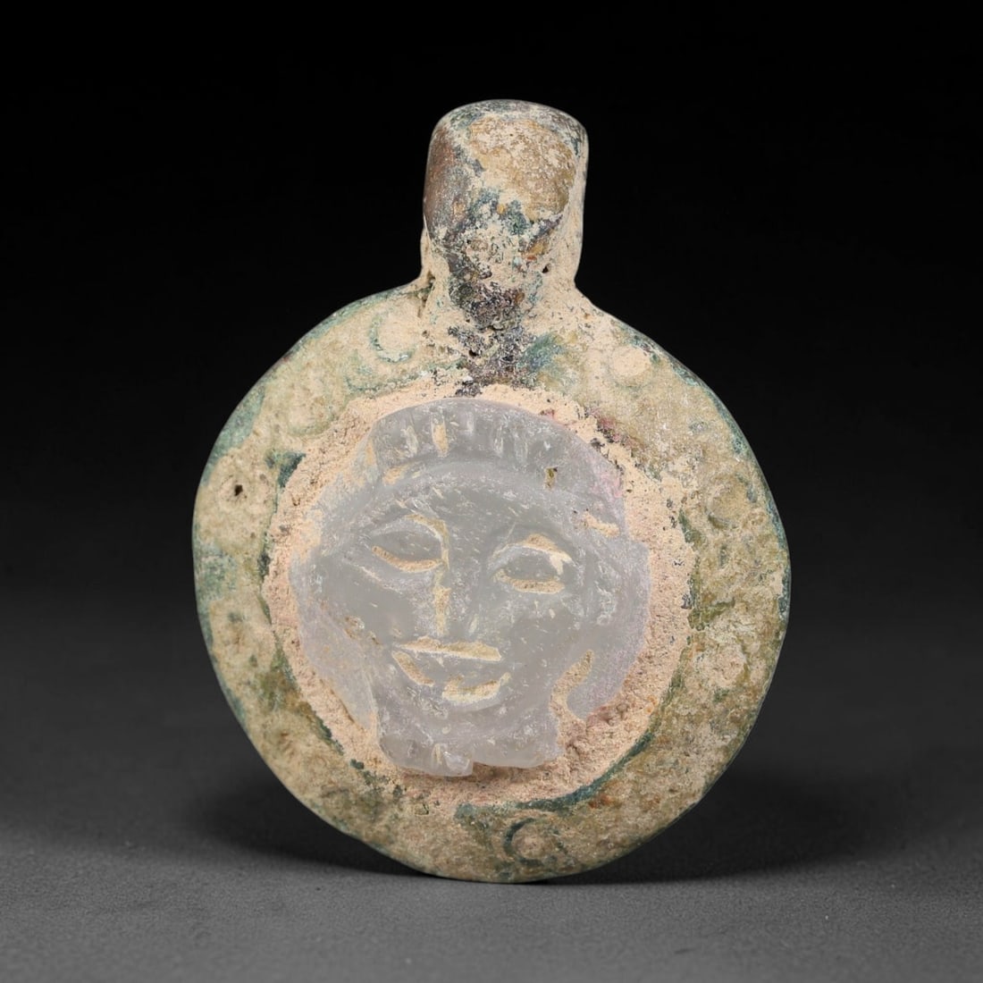 Ancient Medieval Byzantine Bronze Pendant With Stone Cameo (500-1200 CE), 70EH: This antique circular bronze pendant originates from medieval Byzantine cultural tradition, set with an inset carved stone cameo and made to serve as a wearable protective personal amulet. The bronze 