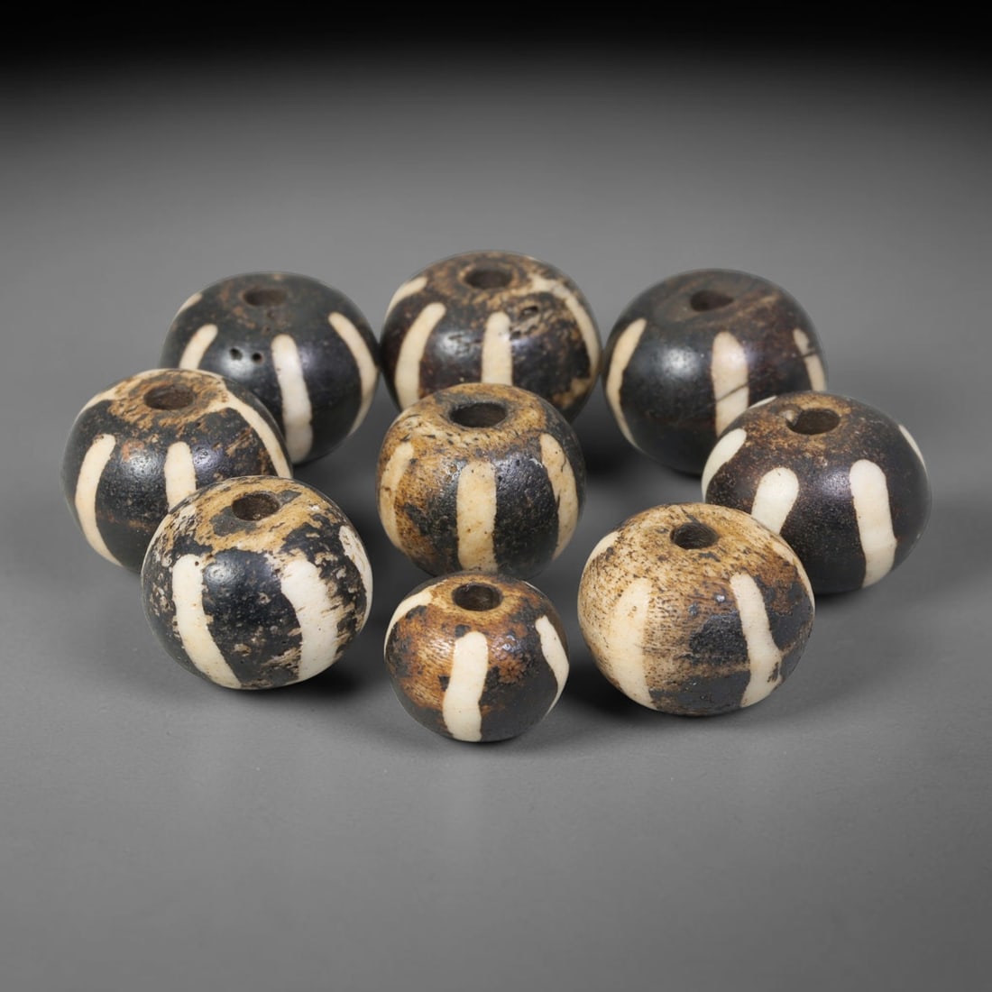 Antique Indo-Himalayan Pumtek Wood Round Striped Etched Beads, 8EV: Fine assembled set of antique Indo-Himalayan pumtek wood round beads decorated with classic vertical etched stripe motifs. The grouping shows natural material variation, deep accumulated patina, and g