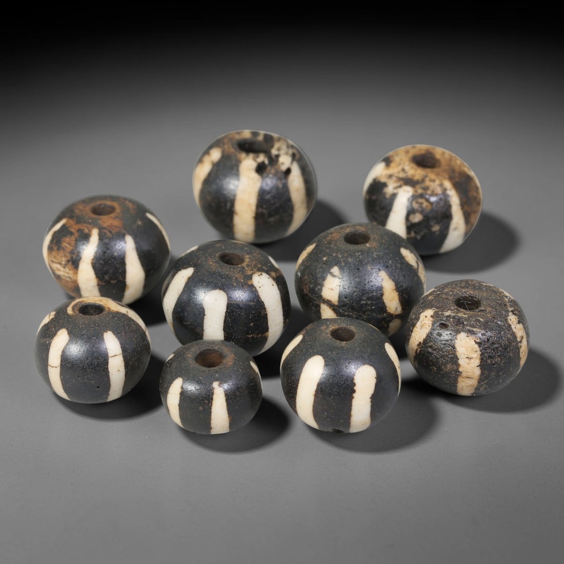 Antique Indo-Himalayan Pumtek Wood Round Striped Etched Beads, 3EV: Fine assembled set of antique Indo-Himalayan pumtek wood round beads decorated with classic vertical etched stripe motifs. The grouping shows natural material variation, deep accumulated patina, and g