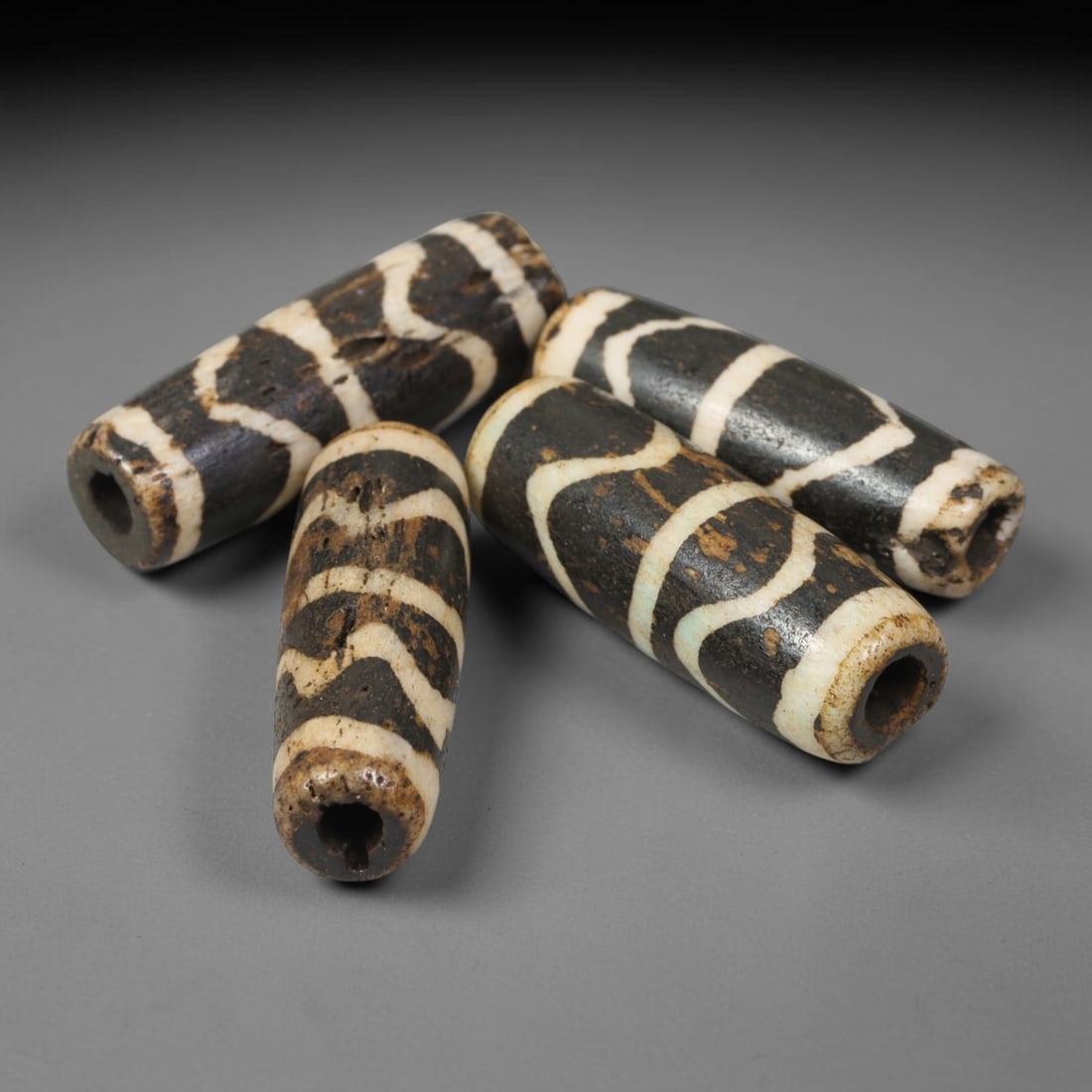 Antique Indo-Himalayan Pumtek Wood Cylindrical Etched Beads, 5EV: Collectible set of four antique Indo-Himalayan pumtek wood cylindrical beads, adorned with classic etched winding symbolic patterns. These beads show prominent aged patina, surface weathering and natu