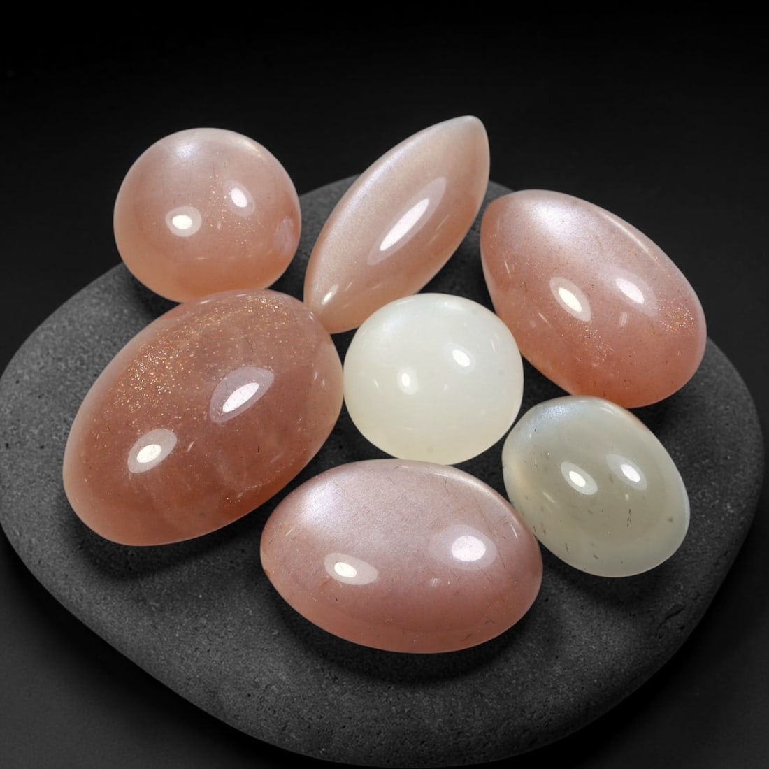 74.13ct Natural Ceylon Moonstone Cabochon Loose Gemstone Parcel Lot, 92EV: This substantial parcel of Ceylon moonstone cabochons showcases soft milky white, warm peach-pink and cool grey-silver tones across smoothly polished oval domed forms. Gentle adularescent sheen drifts