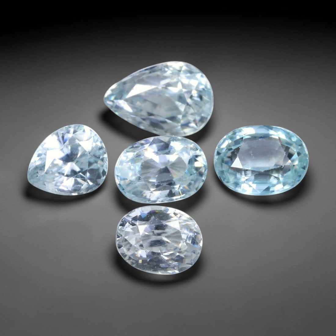 7.52ct Natural Cambodian Ice Blue Zircon Loose Gemstone Parcel Lot, 41EV: This brilliant parcel of blue zircon carries crisp ice-blue colour tones, brought to life by sharp faceting that delivers bright, lively sparkle across every stone. Mixed pear and oval cuts create dyn