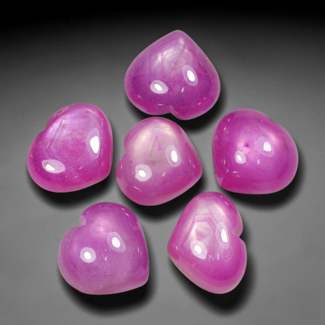 34.14ct Natural Mozambican Ruby Cabochon Loose Gemstone Parcel Lot, 69EV: This distinctive parcel of heart-shaped ruby cabochons displays rich saturated magenta-red colour with visible hexagonal internal growth patterns across smooth polished domed surfaces. Each heart-form