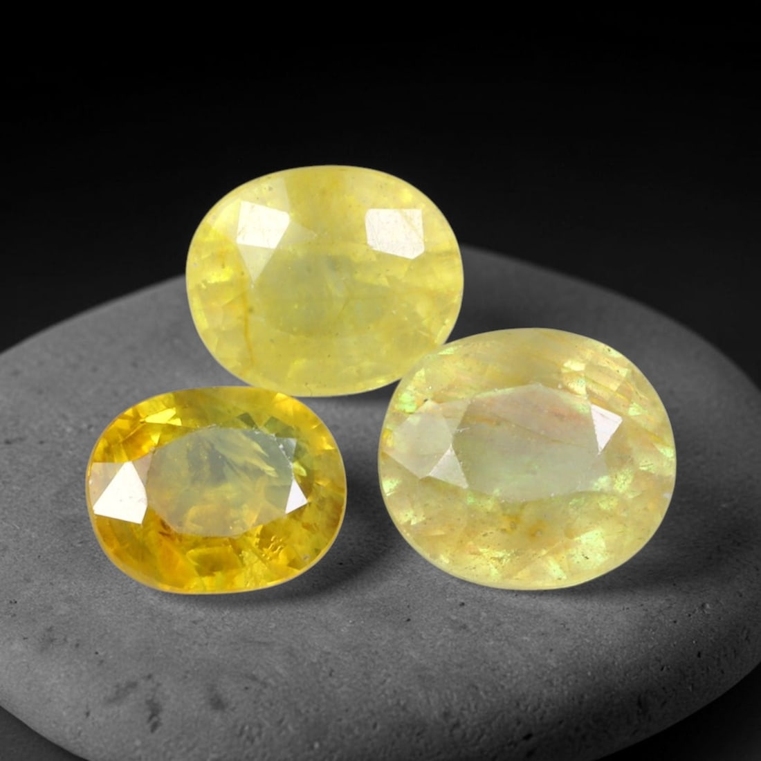 6.03ct Natural Sri Lankan Golden Yellow Sapphire Loose Gemstone Parcel Lot, 47EV: This curated parcel of yellow sapphires shows warm golden-yellow tonal variation across well-proportioned oval faceted cuts. Subtle shifting iridescent highlights appear within the gems, bringing soft