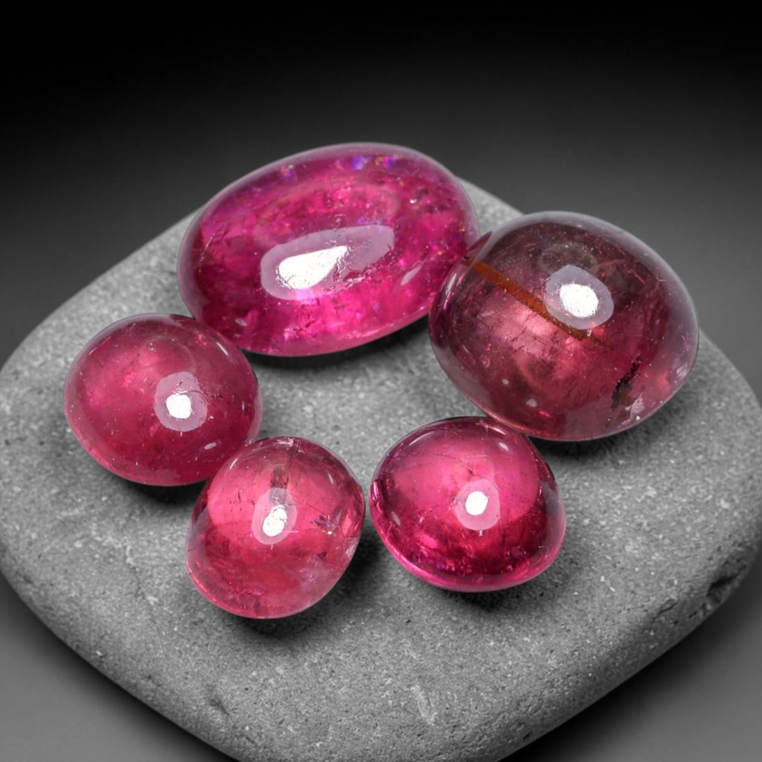 11.03ct Natural Mozambican Rubellite Tourmaline Cabochon Loose Gemstone Parcel Lot, 52EV: This rich parcel of rubellite tourmaline cabochons boasts vivid saturated raspberry-red hues across smooth polished domed surfaces. Light glides across the rounded forms, highlighting deep internal co