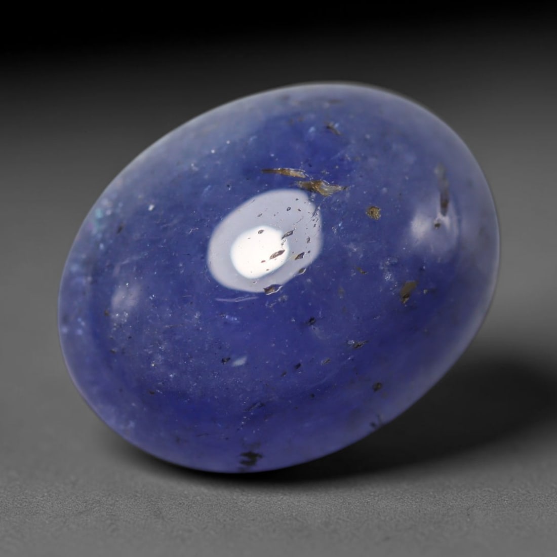 9.94ct Natural Tanzanian Tanzanite Oval Cabochon Loose Gemstone, 65BZ: This smoothly polished oval cabochon is natural tanzanite sourced exclusively from Tanzania, the only known origin for this rare gemstone. It features rich, saturated violet-blue colour across the tra