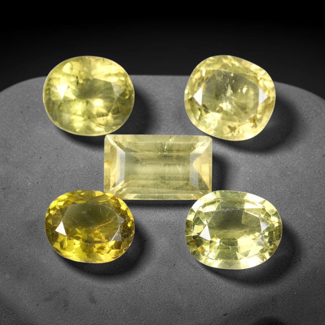 10.49ct Natural Madagascan Lemon Yellow Apatite Loose Gemstone Parcel Lot, 45EV: This bright parcel of apatite exhibits vivid lemon-yellow and golden-yellow hues across mixed oval, pear, cushion and emerald cut forms. Sharp faceting delivers lively sparkle, with warm sunny colour 