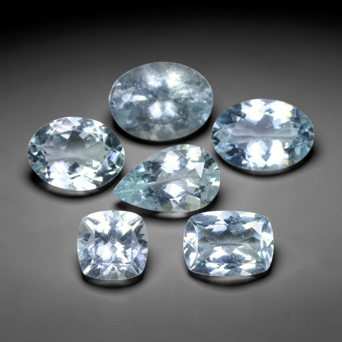 10.61ct Natural Brazilian Sky Blue Aquamarine Loose Gemstone Parcel Lot, 55EV: This lovely parcel of aquamarine displays serene sky-blue cool tones across a varied selection of oval, cushion and emerald faceted cuts. Crisp faceting allows light to travel through each translucent