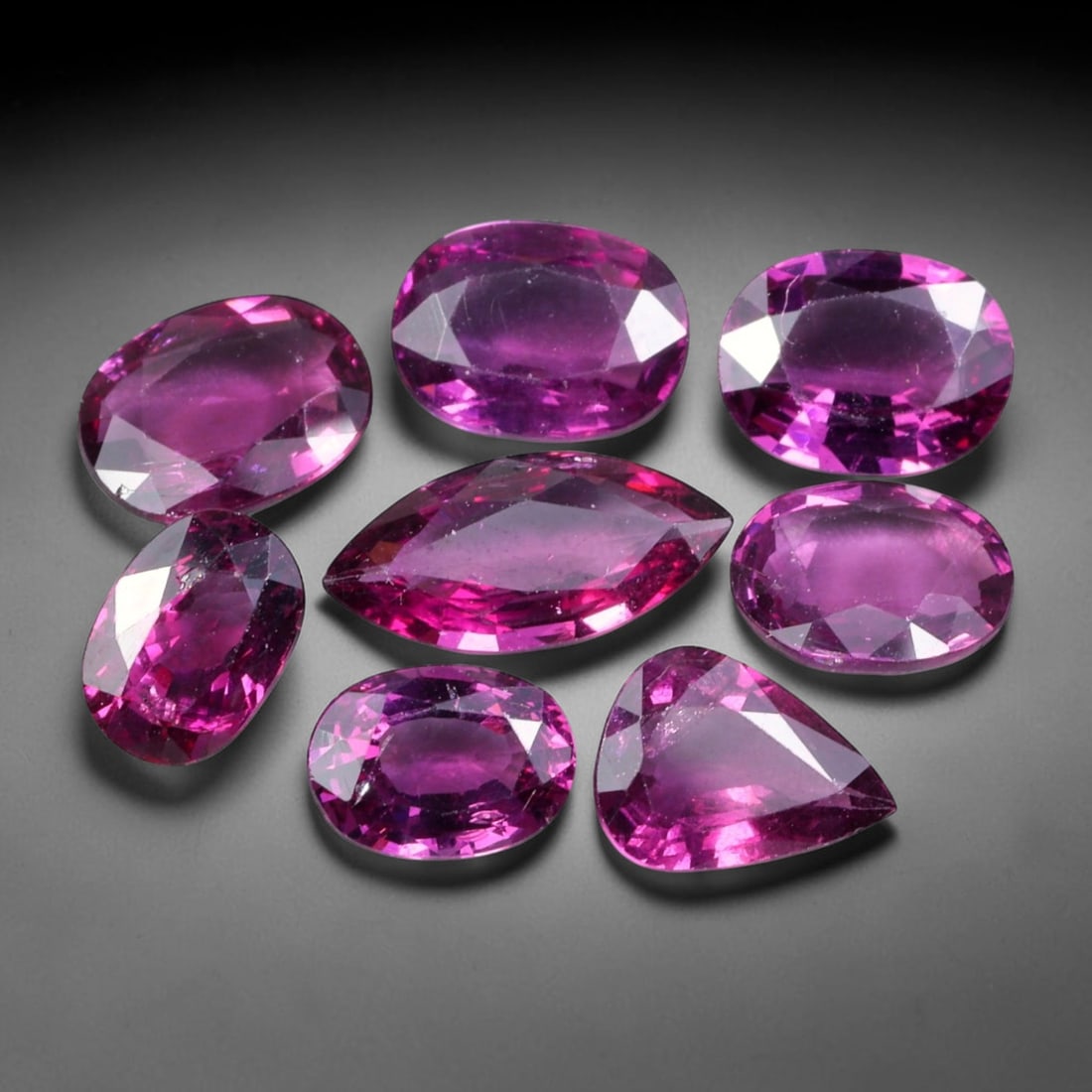 10.78ct Natural Mozambican Rhodolite Garnet Loose Gemstone Parcel Lot, 58EV: This vibrant parcel of rhodolite garnet displays rich saturated magenta-rose tones across a varied assortment of oval, marquise and pear faceted cuts. Precise faceting produces bright sparkle, highlig