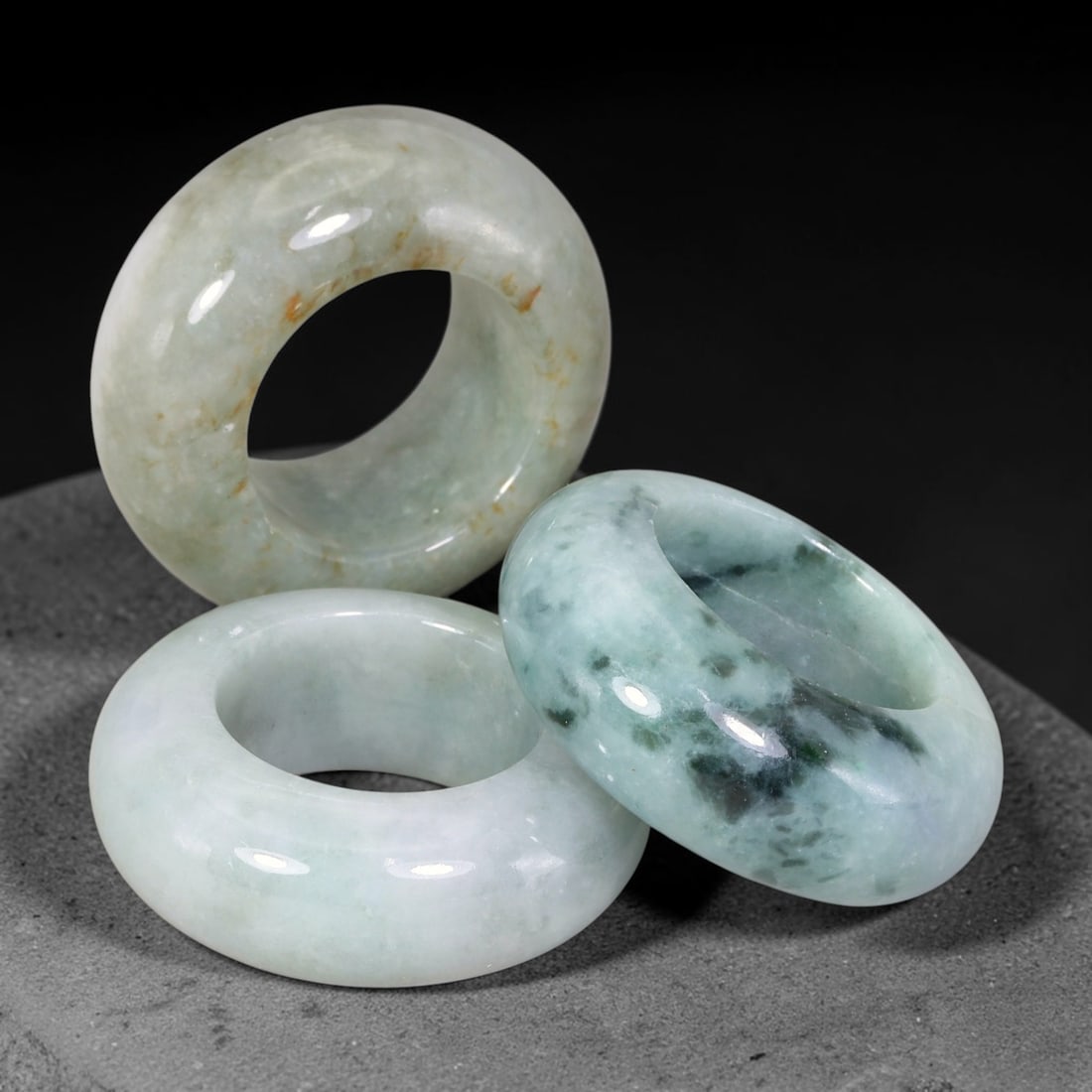 Burmese Type-A Jadeite Jade Thumb Rings Chinese Archer Set, 31EW: Crafted from natural Burmese Type-A jadeite jade, this set of three archer's thumb rings displays varied natural stone tones including pale celadon, deep bluish-green, with scattered russet and dark m