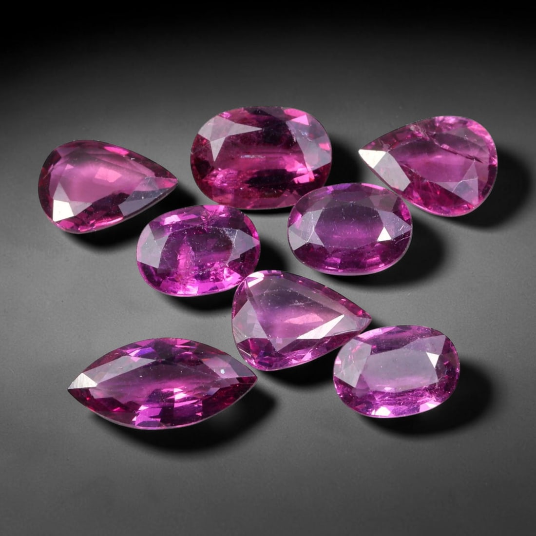9.81ct Natural Mozambican Rhodolite Garnet Loose Gemstone Parcel Lot, 63EV: This vibrant parcel of rhodolite garnet displays rich saturated magenta-rose tones across a varied assortment of oval, marquise and pear faceted cuts. Precise faceting produces bright sparkle, highlig