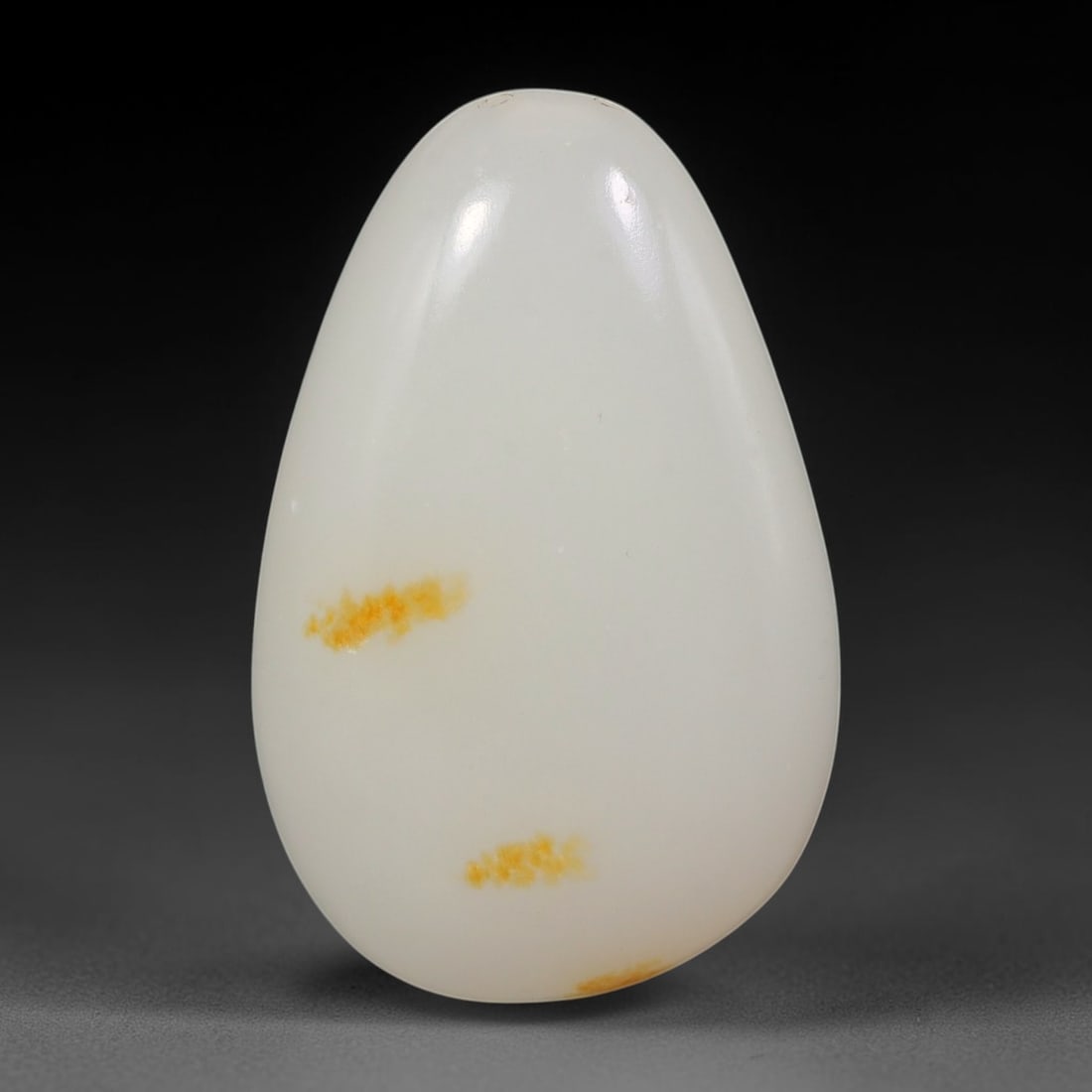 Natural Xinjiang Hetian Nephrite Jade Polished Pebble Stone, 65AS: This smoothly polished alluvial nephrite pebble from Xinjiang features fine creamy-white body material decorated with scattered patches of natural golden-russet skin. Fully rounded and highly lustrous