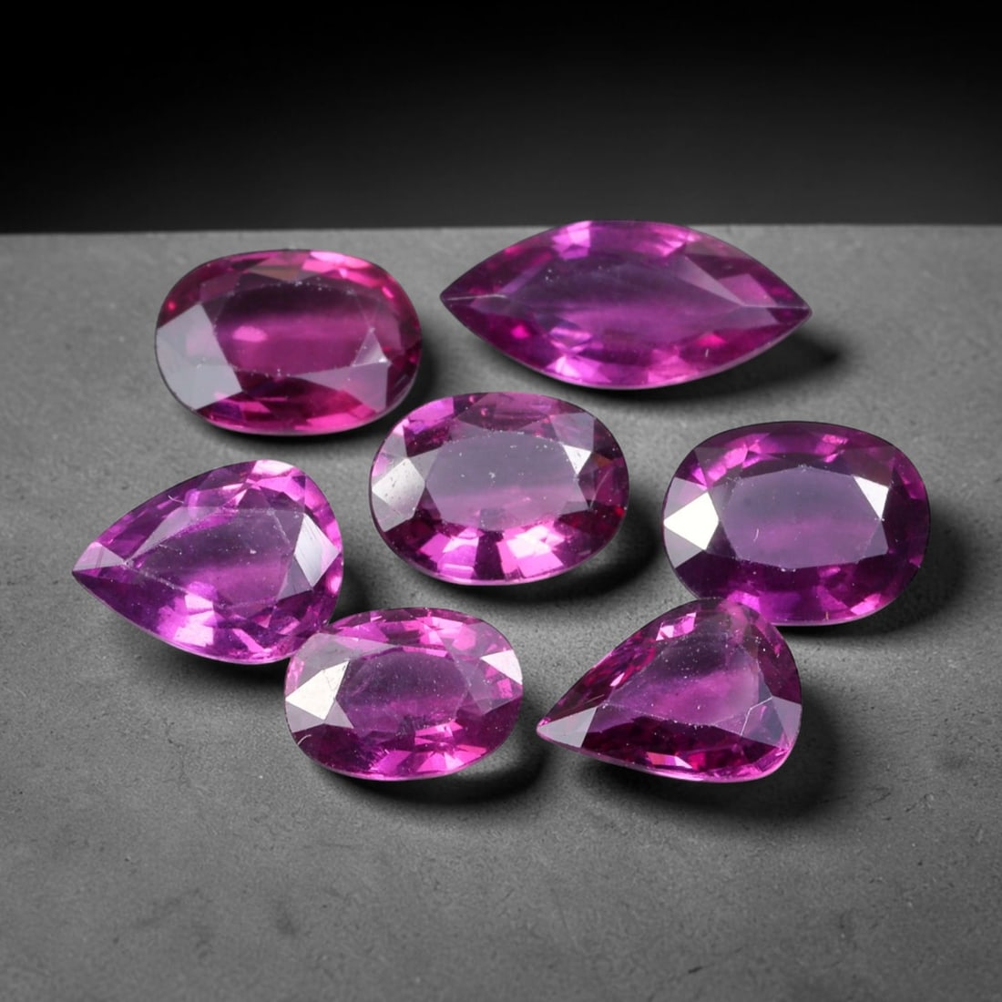 9.77ct Natural Mozambican Rhodolite Garnet Loose Gemstone Parcel Lot, 60EV: This vibrant parcel of rhodolite garnet displays rich saturated magenta-rose tones across a varied assortment of oval, marquise and pear faceted cuts. Precise faceting produces bright sparkle, highlig