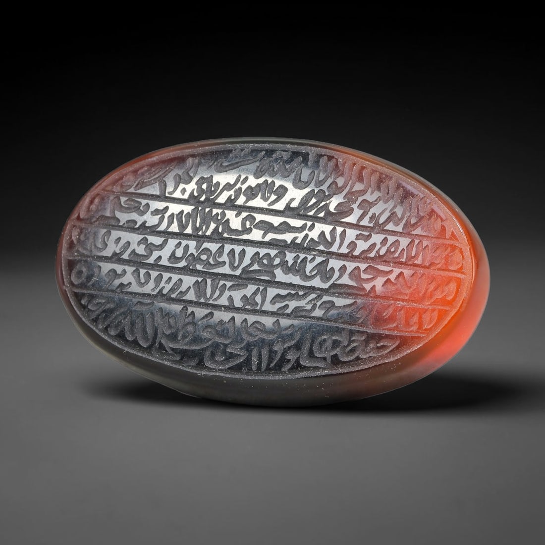 Ancient Medieval Mughal Islamic Carnelian Agate Calligraphic Script Talisman 1526-1857 CE, 82ES: Polished rich-toned carnelian agate cabochon, finely engraved with divided panels of Islamic calligraphic intaglio inscriptions. Deep crisp engraving features segmenting incised lines organizing the s