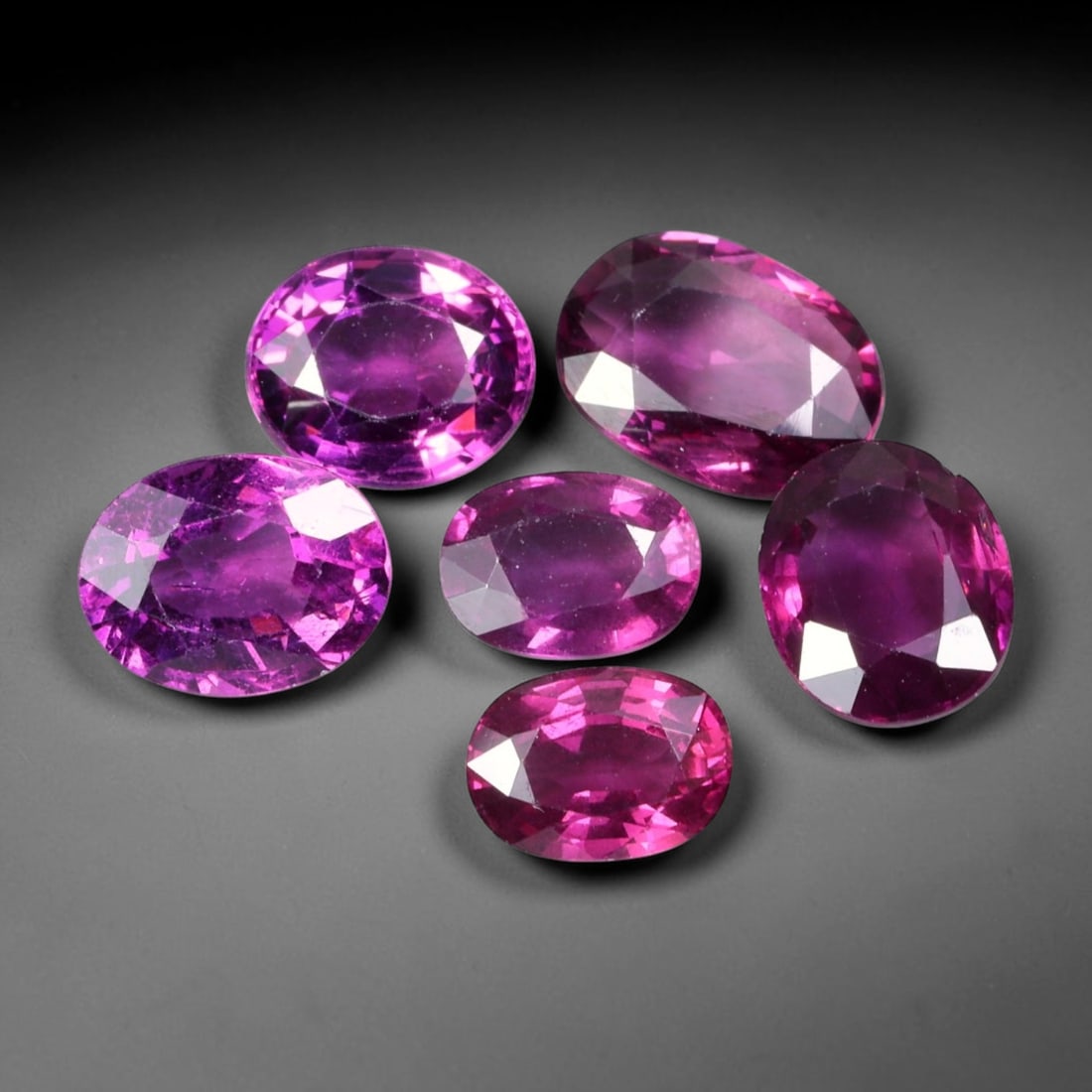 10.66ct Natural Mozambican Rhodolite Garnet Loose Gemstone Parcel Lot, 62EV: This vibrant parcel of rhodolite garnet displays rich saturated magenta-rose tones across a varied assortment of oval, marquise and pear faceted cuts. Precise faceting produces bright sparkle, highlig