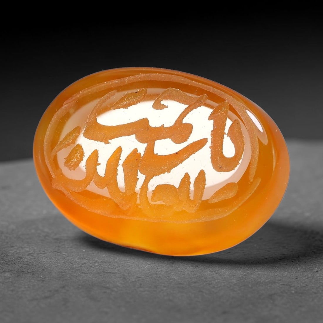 Ancient Medieval Mughal Islamic Carnelian Agate Calligraphic Script Talisman 1526-1857 CE, 40ET: Polished rich-toned carnelian agate cabochon, finely engraved with divided panels of Islamic calligraphic intaglio inscriptions. Deep crisp engraving features segmenting incised lines organizing the s