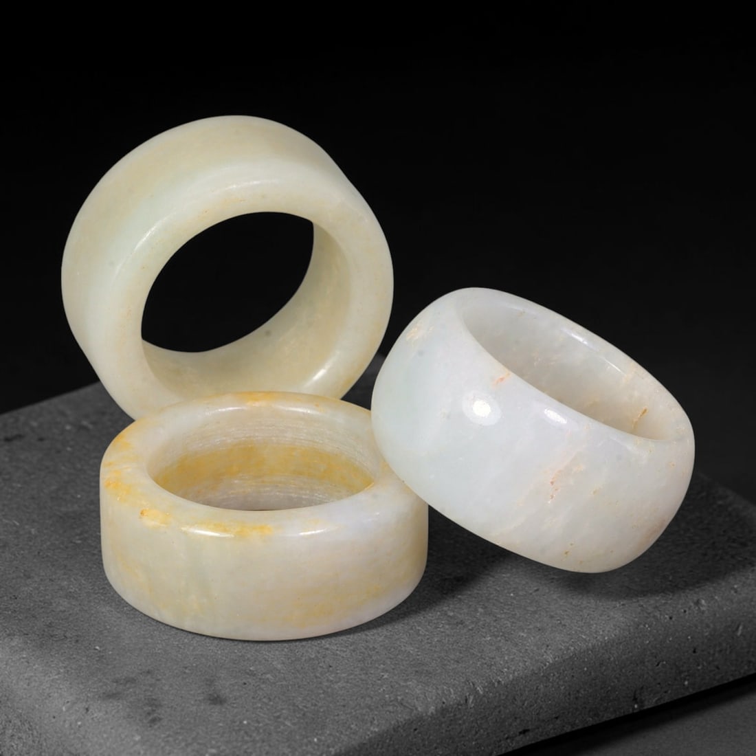 Burmese Type-A Jadeite Jade Thumb Rings Chinese Archer Set, 27EW: Crafted from natural Burmese Type-A jadeite jade, this set of three archer's thumb rings features pale milky stone with natural golden-yellow mineral staining and internal inclusions. Each piece is sh