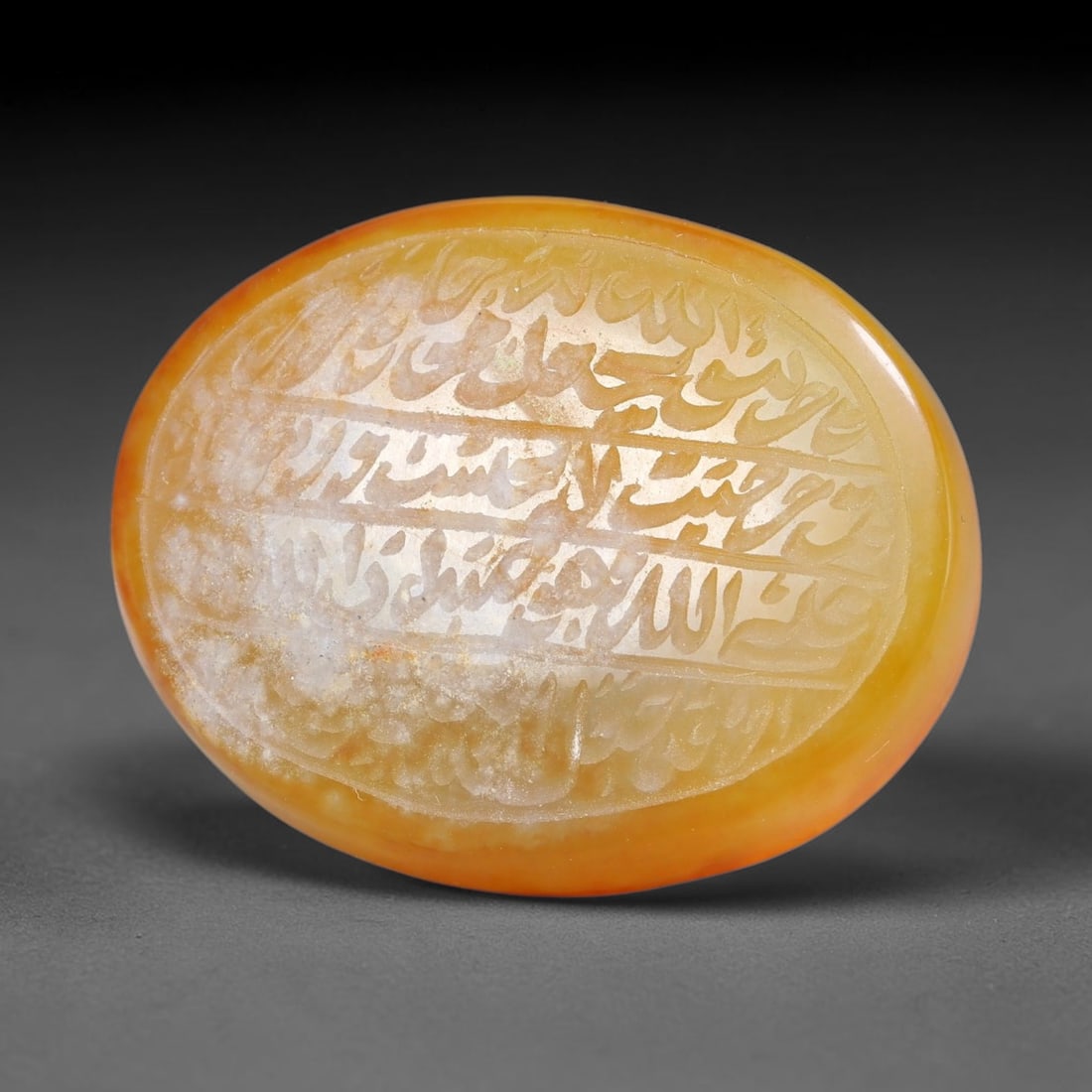 Ancient Medieval Mughal Islamic Carnelian Agate Calligraphic Script Talisman 1526-1857 CE, 87ES: Polished rich-toned carnelian agate cabochon, finely engraved with divided panels of Islamic calligraphic intaglio inscriptions. Deep crisp engraving features segmenting incised lines organizing the s