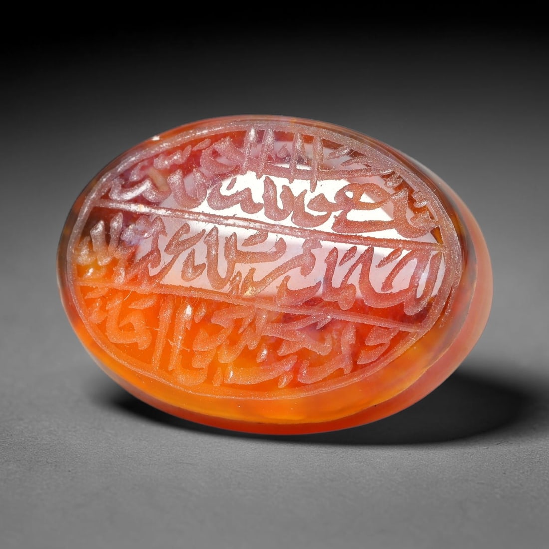 Ancient Medieval Mughal Islamic Carnelian Agate Calligraphic Script Talisman 1526-1857 CE, 14ET: Polished rich-toned carnelian agate cabochon, finely engraved with divided panels of Islamic calligraphic intaglio inscriptions. Deep crisp engraving features segmenting incised lines organizing the s