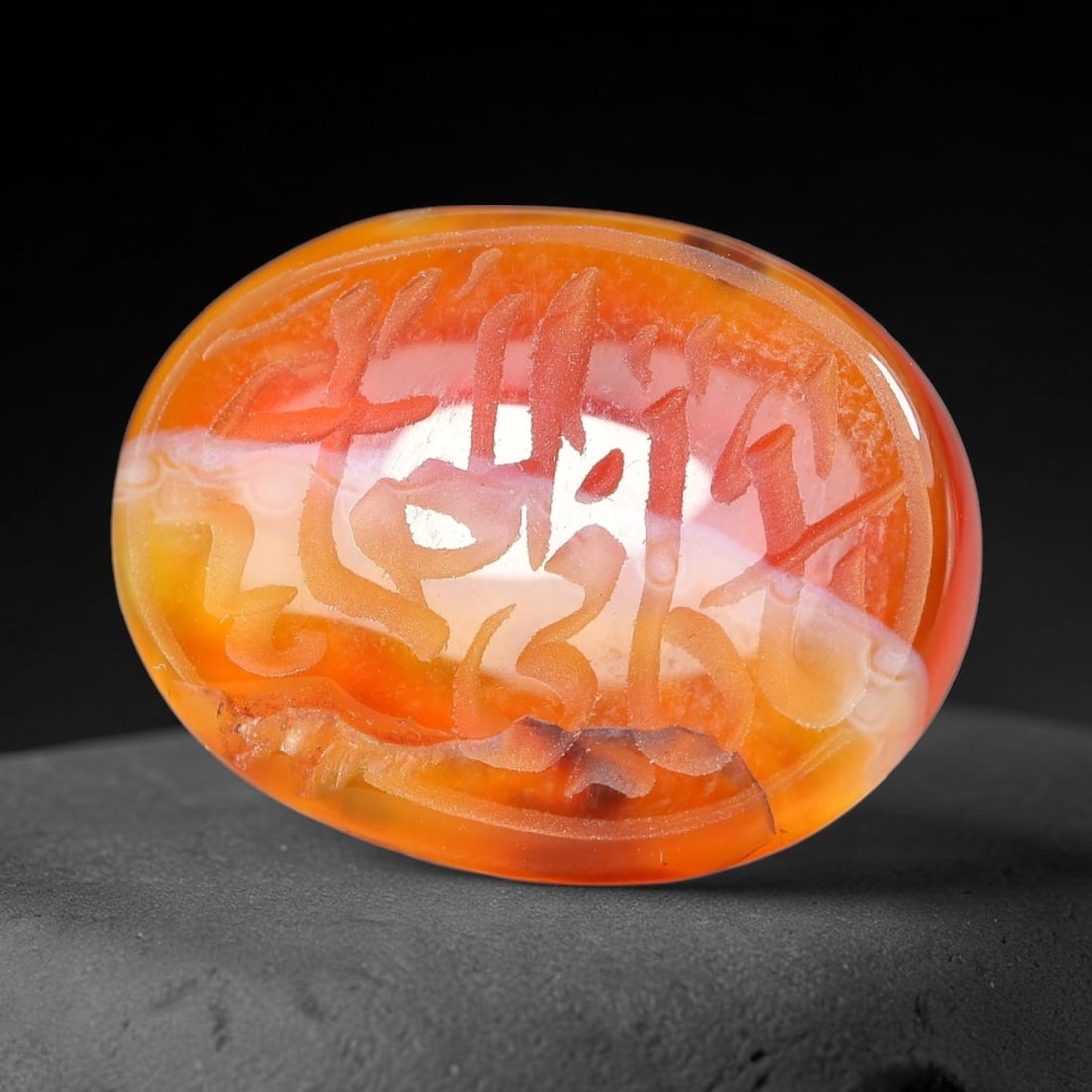 Ancient Medieval Mughal Islamic Carnelian Agate Calligraphic Script Talisman 1526-1857 CE, 39ET: Polished rich-toned carnelian agate cabochon, finely engraved with divided panels of Islamic calligraphic intaglio inscriptions. Deep crisp engraving features segmenting incised lines organizing the s