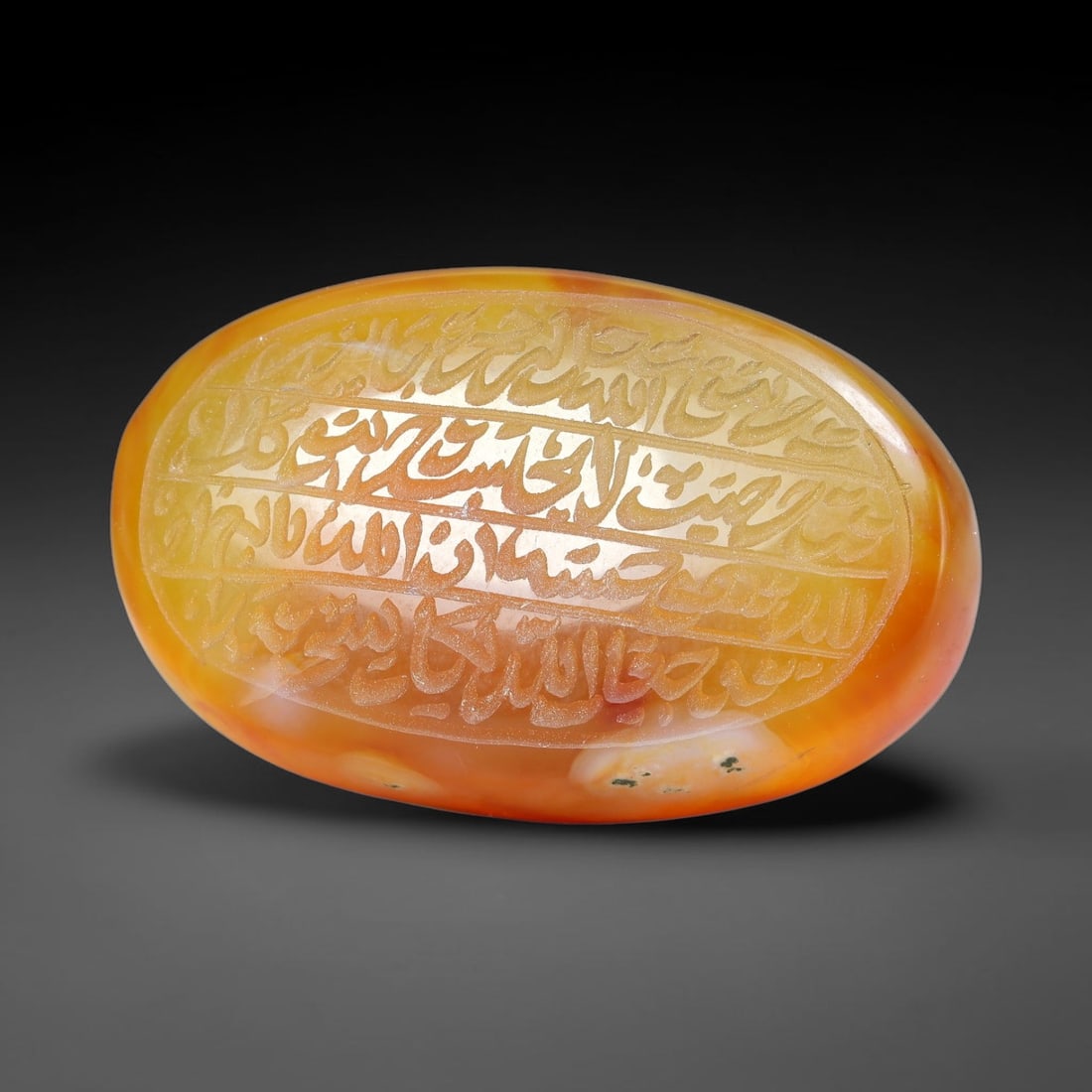 Ancient Medieval Mughal Islamic Carnelian Agate Calligraphic Script Talisman 1526-1857 CE, 97ES: Polished rich-toned carnelian agate cabochon, finely engraved with divided panels of Islamic calligraphic intaglio inscriptions. Deep crisp engraving features segmenting incised lines organizing the s
