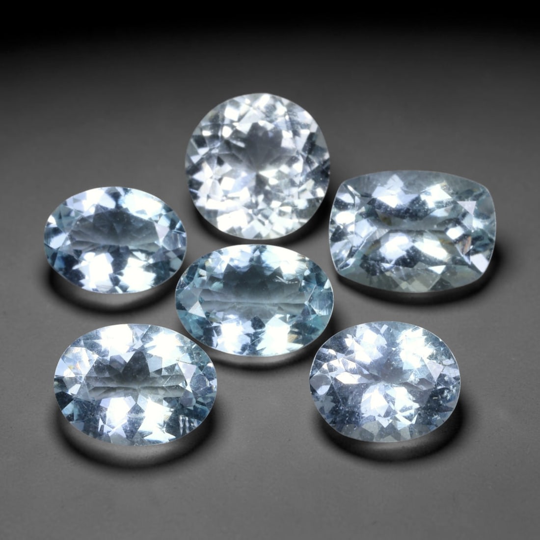 11.12ct Natural Brazilian Sky Blue Aquamarine Loose Gemstone Parcel Lot, 54EV: This lovely parcel of aquamarine displays serene sky-blue cool tones across a varied selection of oval, cushion and emerald faceted cuts. Crisp faceting allows light to travel through each translucent