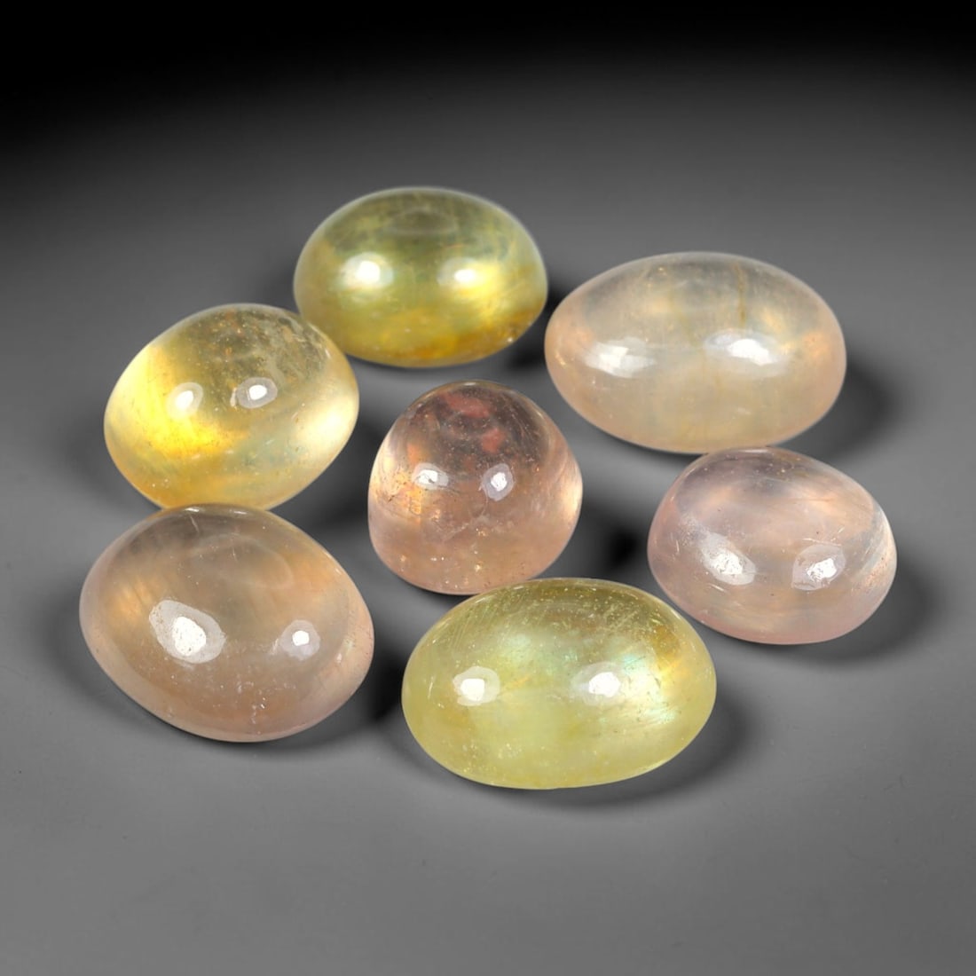 19.01ct Natural Sri Lankan Multi-Tone Sapphire Cabochon Loose Gemstone Parcel Lot, 25EV: This lovely parcel of sapphire cabochons features soft blended tones of pale yellow, champagne and subtle blush pink across smooth polished oval domed surfaces. Gentle iridescent internal reflections 