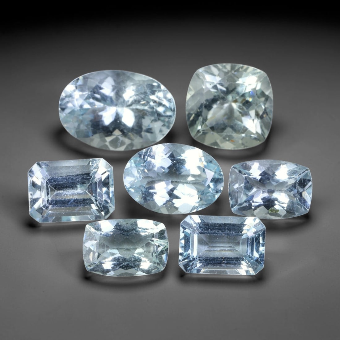 13.48ct Natural Brazilian Sky Blue Aquamarine Loose Gemstone Parcel Lot, 57EV: This lovely parcel of aquamarine displays serene sky-blue cool tones across a varied selection of oval, cushion and emerald faceted cuts. Crisp faceting allows light to travel through each translucent