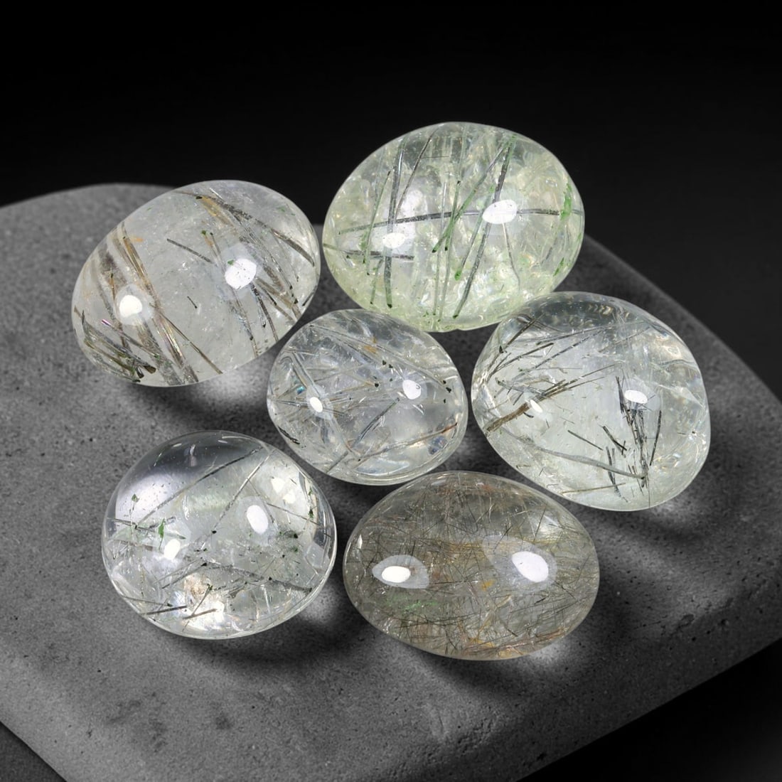 131.07ct Natural Brazilian Rutile Quartz Cabochon Parcel Lot, 54EW: This polished parcel of oval cabochons features clear transparent quartz host densely interspersed with fine metallic black rutile needle inclusions. Each domed high-gloss cabochon displays distinct i