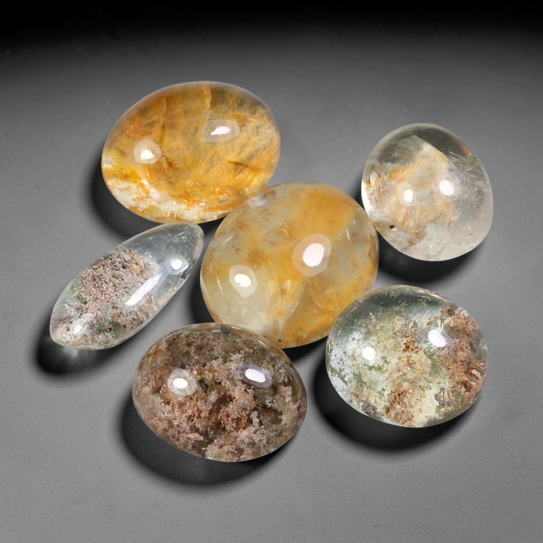 191.02ct Natural Brazilian Phantom Quartz Cabochon Parcel Lot, 60EW: This polished cabochon parcel of natural phantom quartz features transparent clear quartz host stone enclosing intricate internal phantom mineral deposits. Each oval cabochon displays unique scenic in