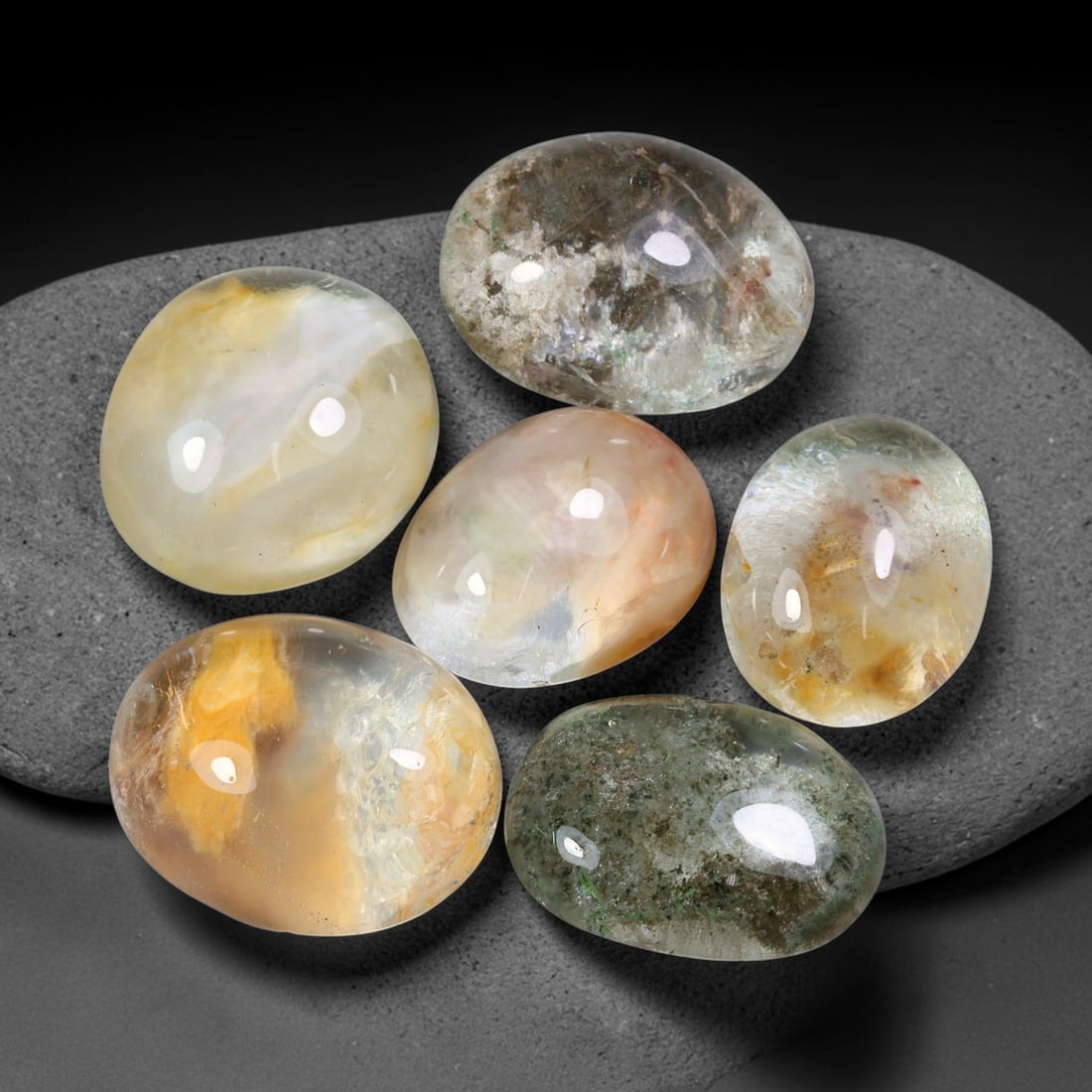 199.57ct Natural Brazilian Phantom Quartz Cabochon Parcel Lot, 59EW: This polished cabochon parcel of natural phantom quartz features transparent clear quartz host stone enclosing intricate internal phantom mineral deposits. Each oval cabochon displays unique scenic in