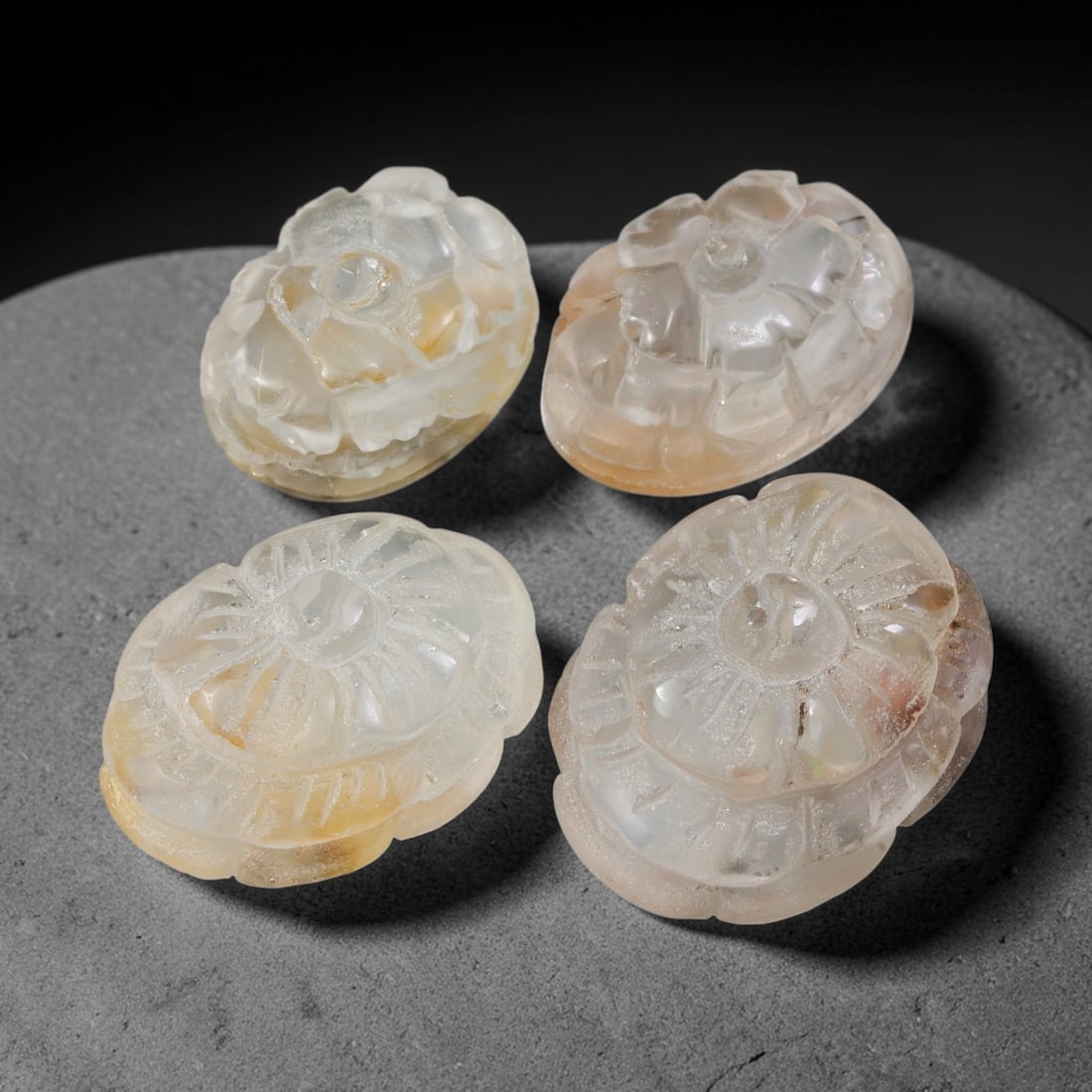 252.78ct Natural Brazilian Carved Phantom Quartz Cabochon Parcel Lot, 71EW: This parcel consists of four oval cabochons carved from natural phantom quartz, featuring finely sculpted multi-layer floral relief motifs across the domed surfaces. The translucent milky-clear quartz