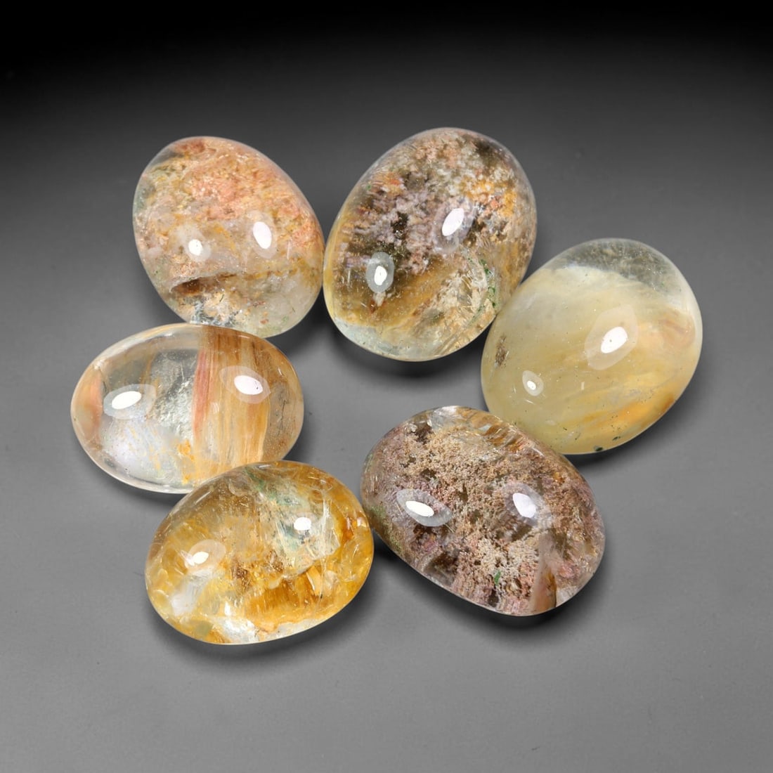 179ct Natural Brazilian Phantom Quartz Cabochon Parcel Lot, 64EW: This polished cabochon parcel of natural phantom quartz features transparent clear quartz host stone enclosing intricate internal phantom mineral deposits. Each oval cabochon displays unique scenic in