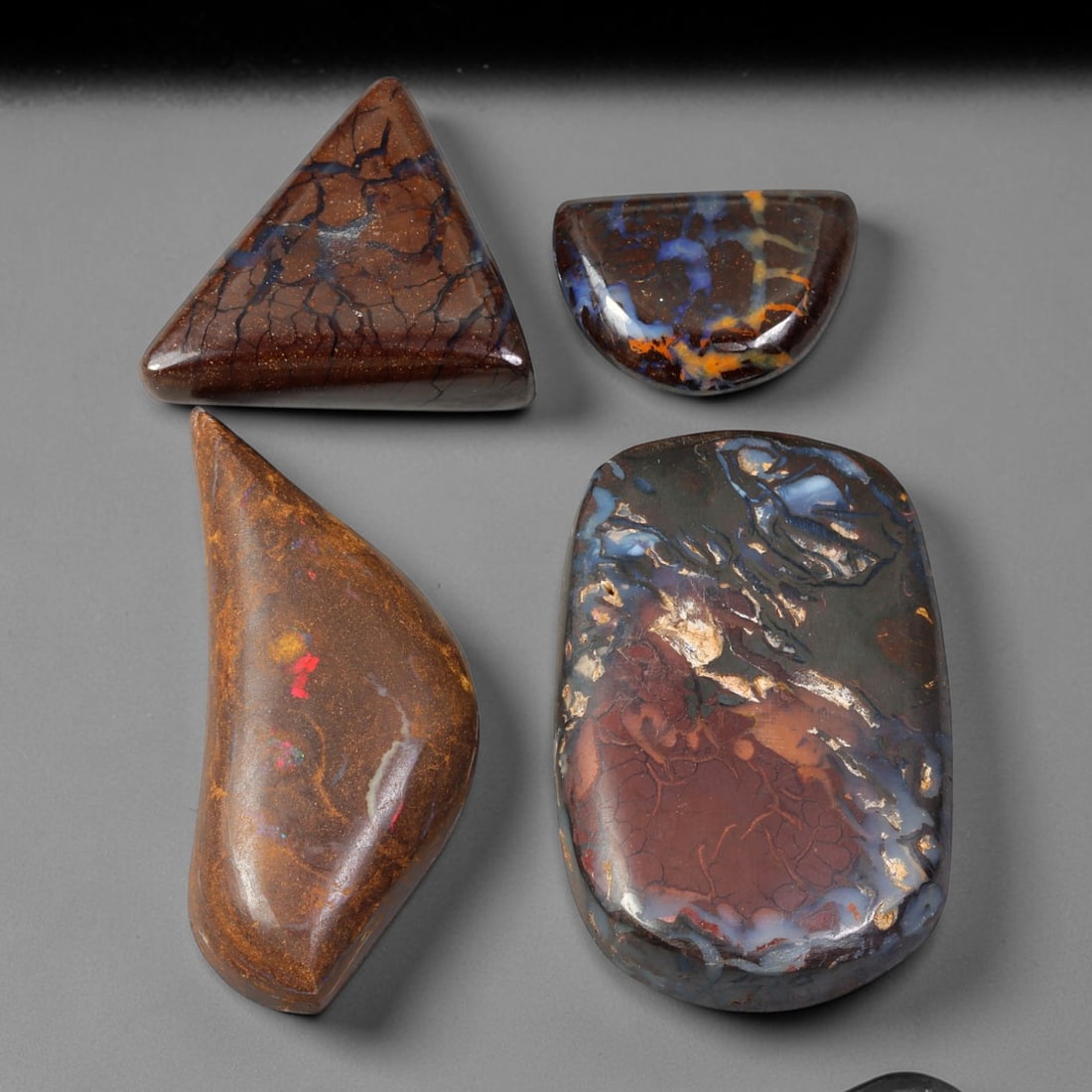 138.74ct Natural Australian Queensland Boulder Opal Cabochon Parcel Lot, 48EX: This polished cabochon parcel features six finished boulder opal cabochons with rich ironstone host matrix interlaced by vivid opal vein patterns. The cabochons display striking earthy brown-orange we