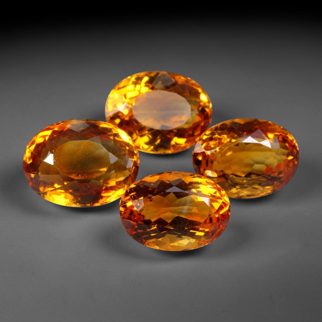 31.70ct Natural Brazilian Madeira Citrine Faceted Parcel Lot, 32EX: This faceted parcel holds oval cut madeira citrine gemstones displaying rich deep golden-orange saturated colour. Precision faceted surfaces deliver bright light return and sparkling brilliance, showc