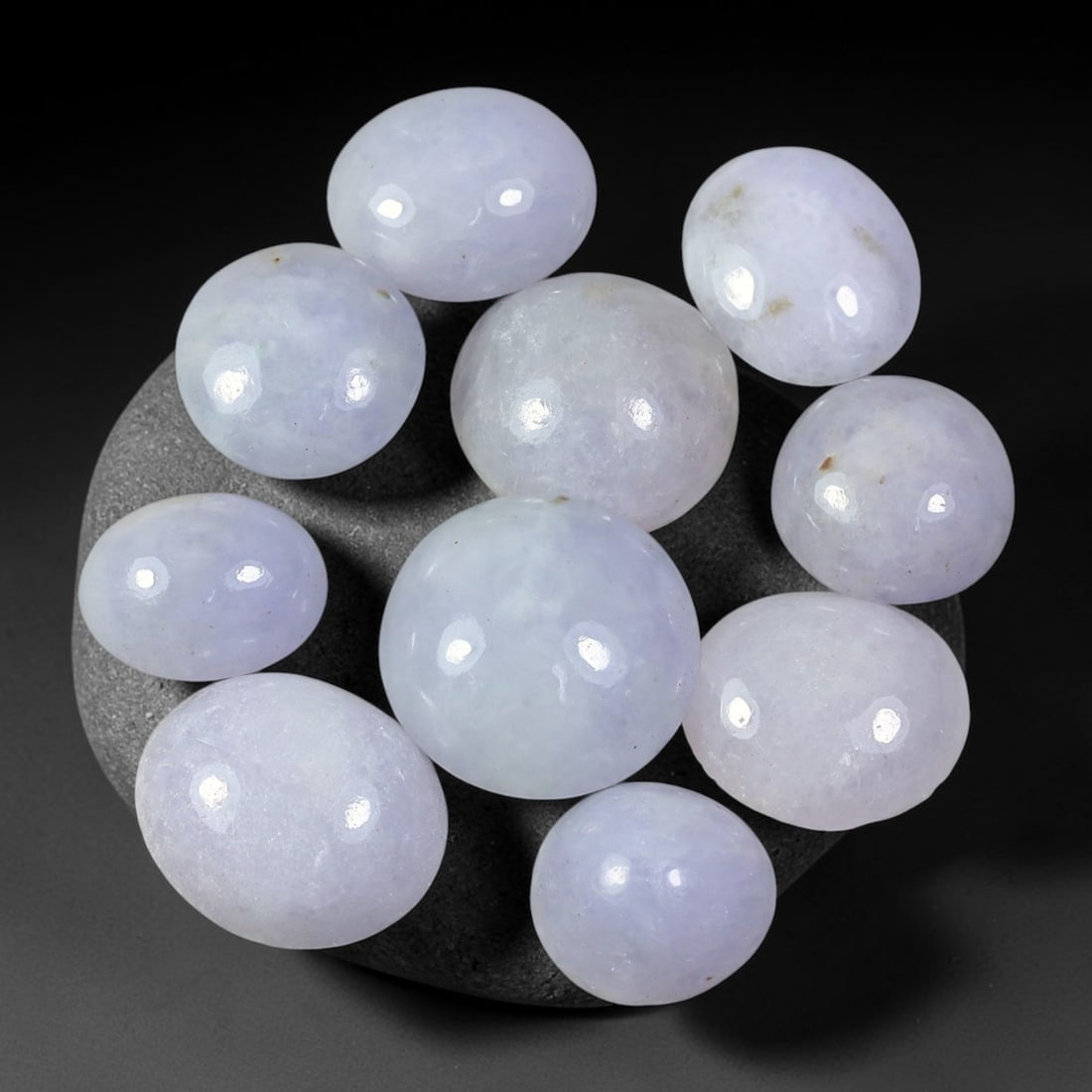 62.60ct Natural Burmese Type A Lavender Jadeite Jade Cabochon Parcel Lot, 39EX: This polished cabochon parcel features oval and round cabochon Type A jadeite jade displaying soft lavender-lilac body tones across the set. Smooth high-gloss domed surfaces showcase gentle colour var