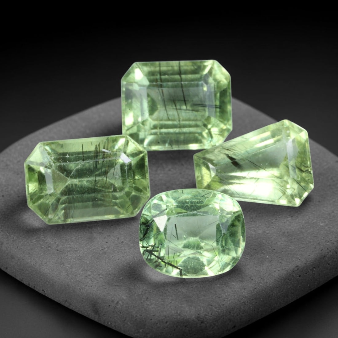 11.43ct Natural Pakistani Olive Green Rutilated Peridot Faceted Parcel Lot, 9EY: This faceted parcel features mixed emerald-cut and cushion-cut peridot displaying soft olive-green body colour with prominent dark needle-like rutile inclusions distributed through the transparent gem