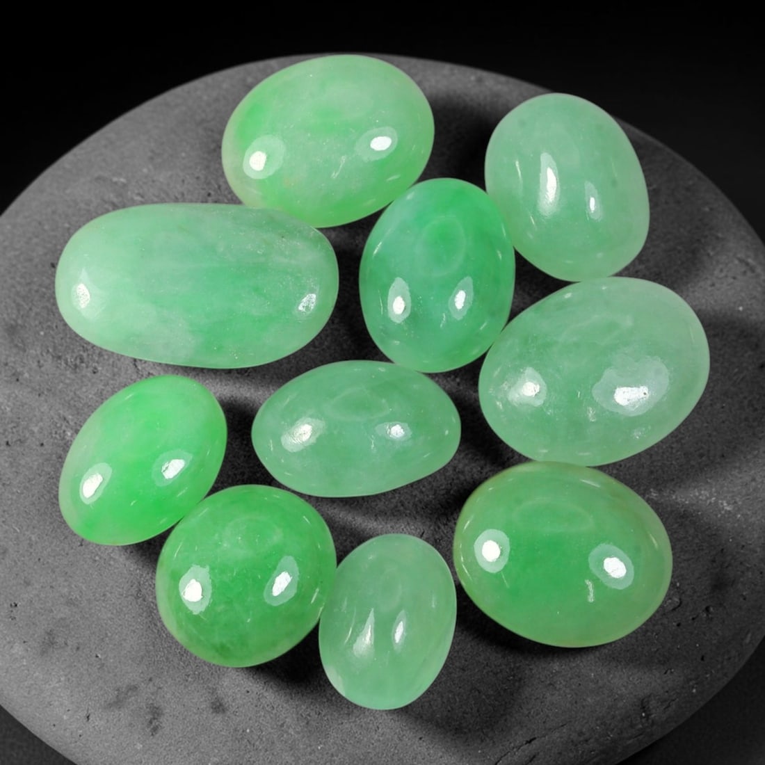 28.77ct Natural Burmese Type A Jadeite Jade Cabochon Parcel Lot, 47EX: This oval cabochon parcel consists of polished Type A jadeite cabochons showing soft pastel to medium lively green colour shades across smooth domed surfaces. Glossy polished finishes reveal natural i