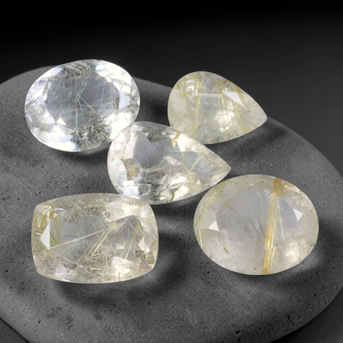 34.13ct Natural Brazilian Rutile Quartz Faceted Parcel Lot, 30EX: This faceted parcel consists of mixed oval, pear and cushion cut rutile quartz gems set within transparent clear quartz host. Sharp polished facet planes deliver bright light performance, showcasing a