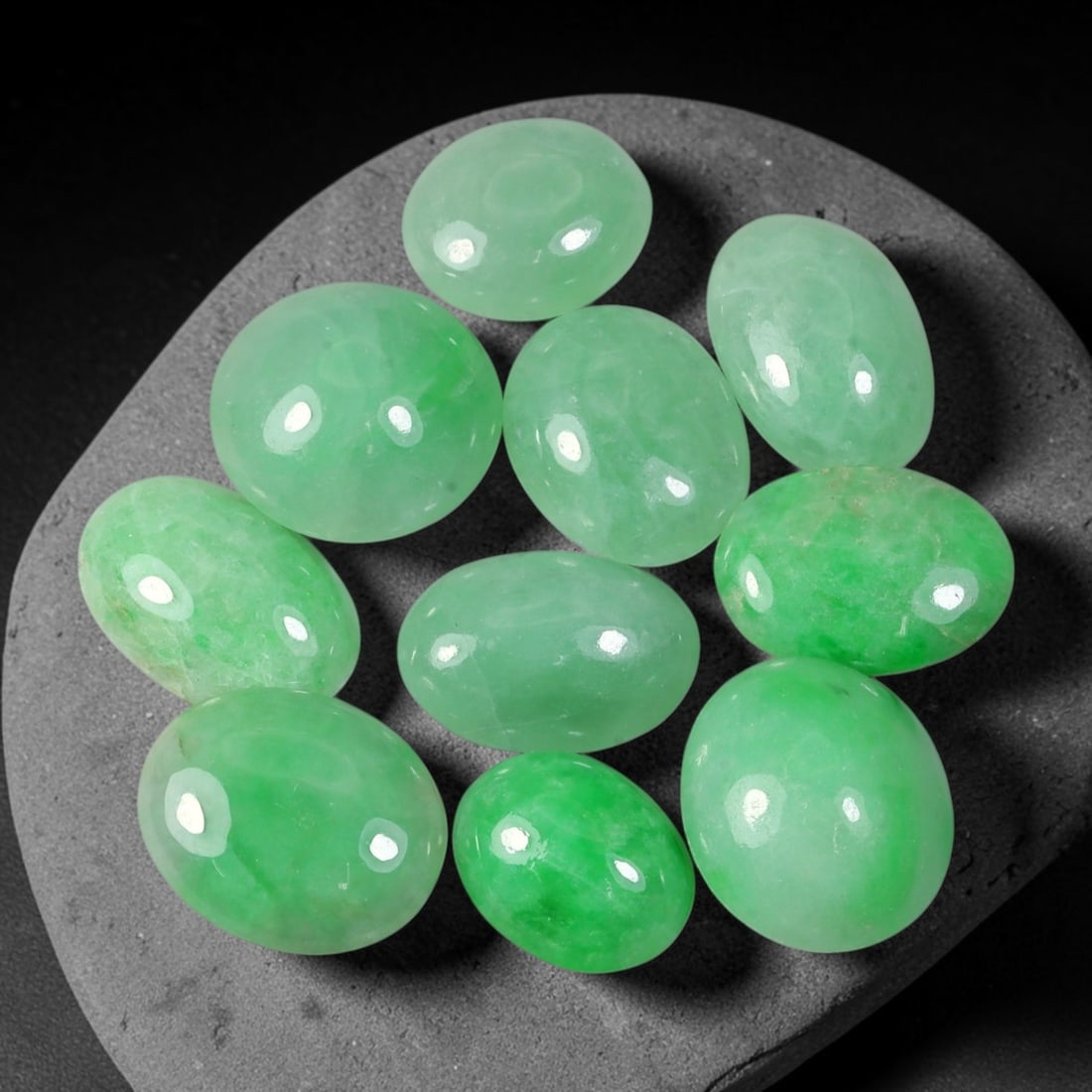 32.73ct Natural Burmese Type A Jadeite Jade Cabochon Parcel Lot, 45EX: This oval cabochon parcel consists of polished Type A jadeite cabochons showing soft pastel to medium lively green colour shades across smooth domed surfaces. Glossy polished finishes reveal natural i